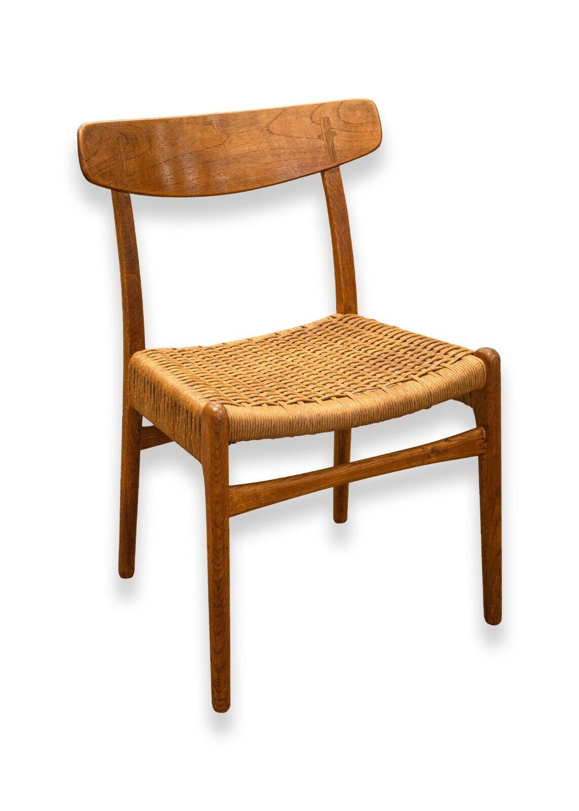 A set of 4 mid century modern Hans Wegner teak wood CH23 side dining chairs. This set of wonderful dining chairs are from legendary furniture designer Hans Wegner. These chairs feature a full teak wood construction, rattan seats, and a gorgeous