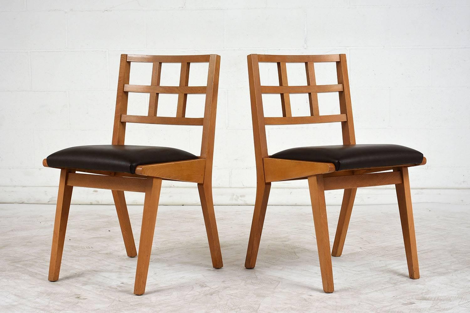 This set of four 1960s Mid-Century Modern style dining chairs feature a light walnut color stained wood frame. The backrest has a geometric pattern with tapered legs. The seats have been professionally upholstered in a brown color leather. This set