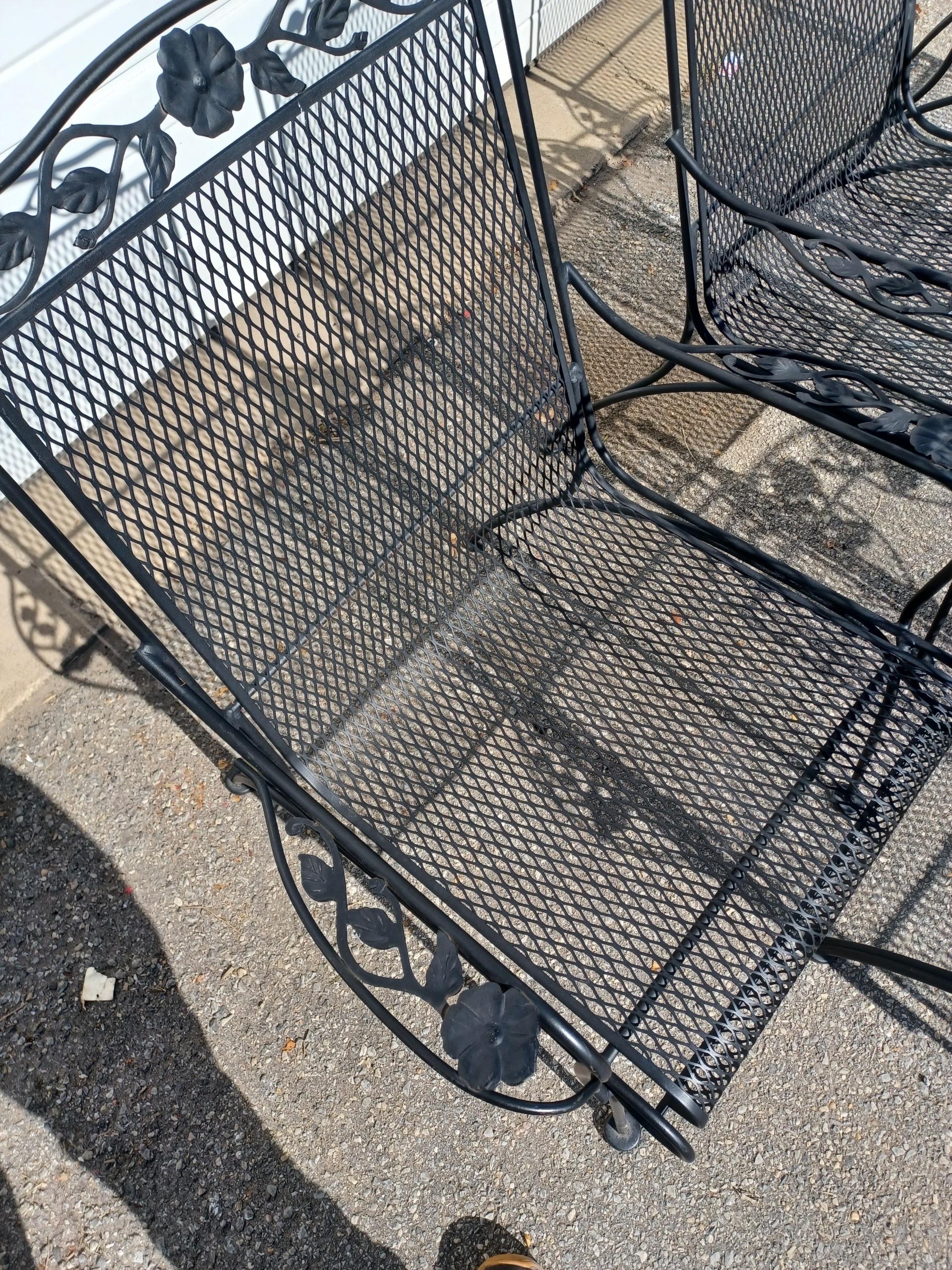 Set of 4 Mid-Century Modern Woodard Outdoor Chairs 
Offered is a set of 4 mid-century modern outdoor chairs by Woodard. Features enameled and woven wrought iron with a floral pattern at the head of the chair.  The chairs are structurally sound, in