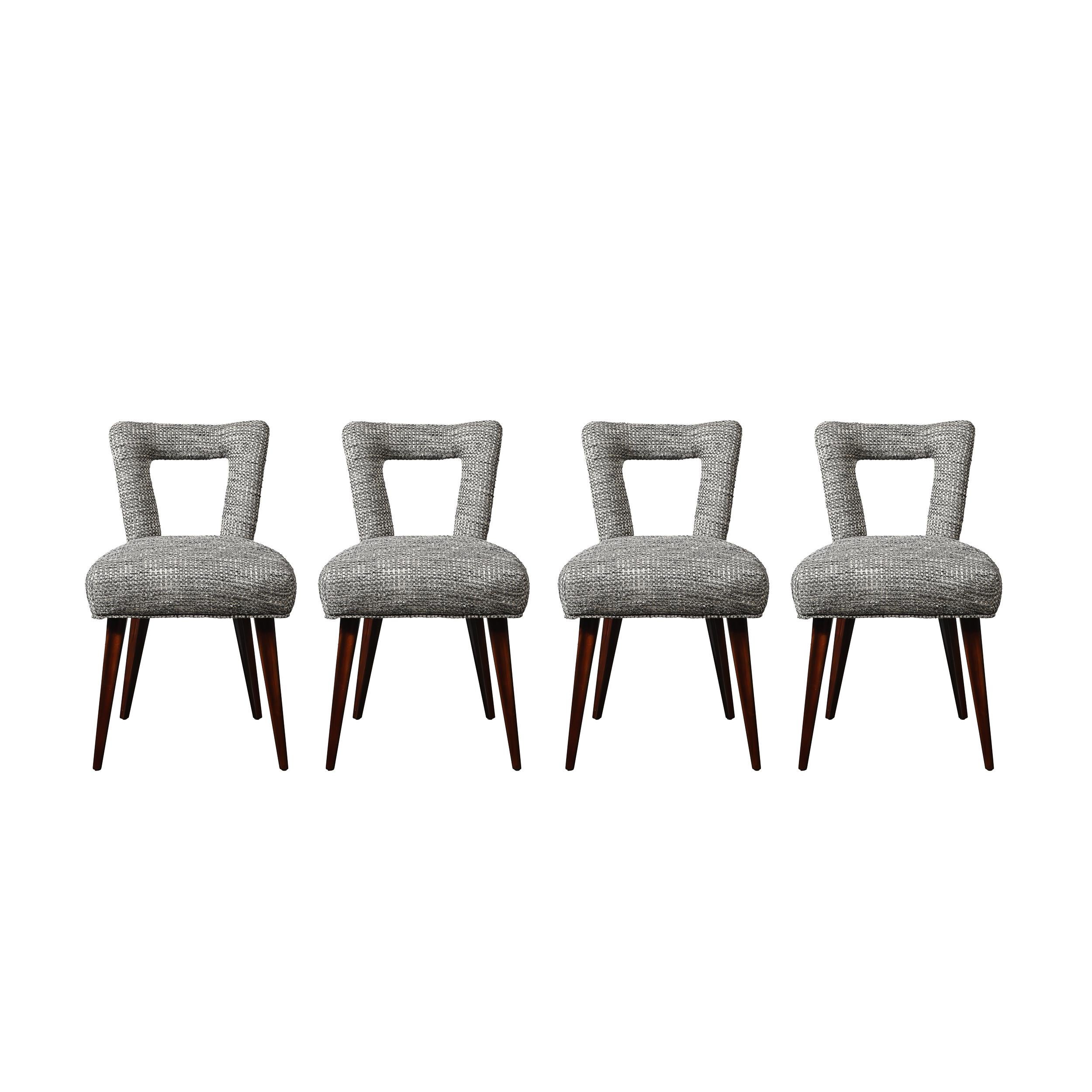 Questo elegante set di quattro sedie da pranzo della metà del secolo scorso cattura l'estetica senza tempo degli anni '50 con il suo design elegante, l'artigianato esperto e l'uso attento dei materiali. Il design con schienale aperto enfatizza la