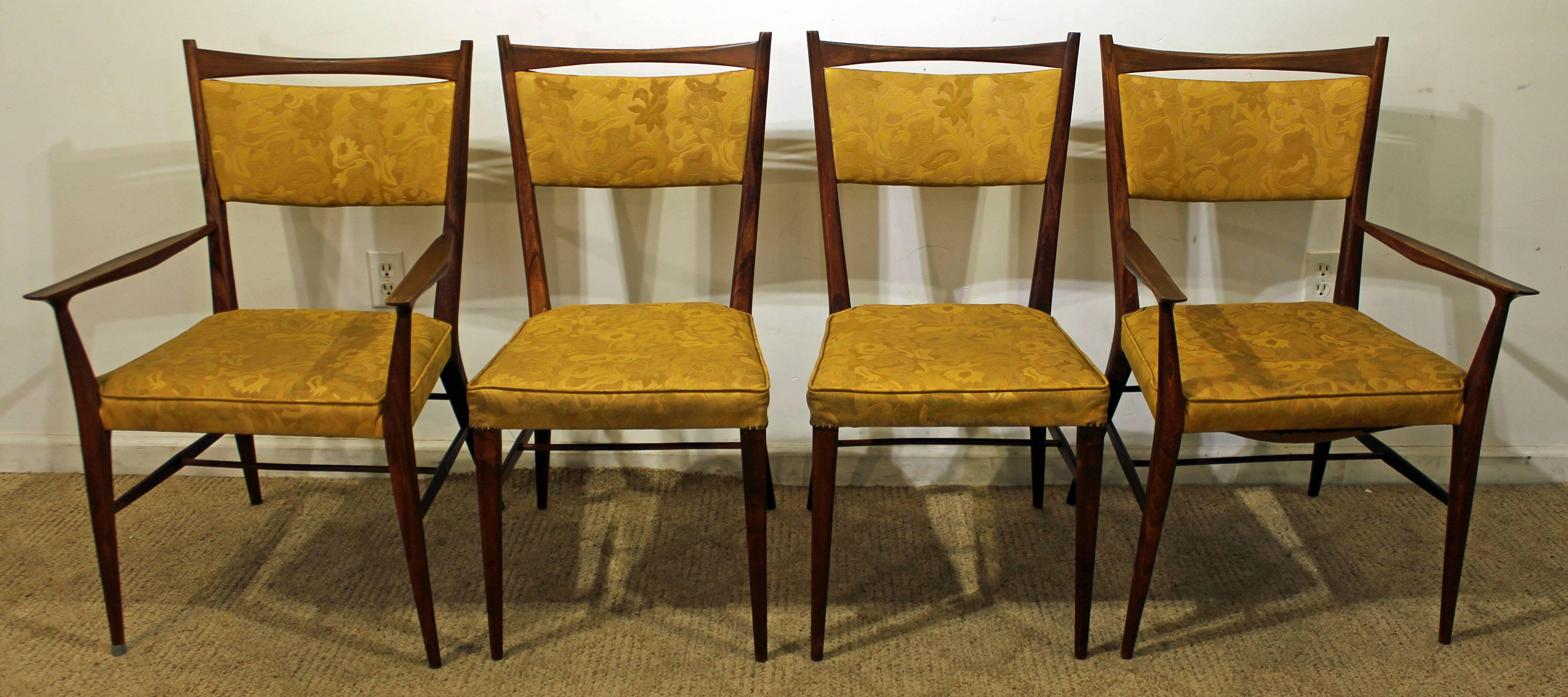 These chairs were designed by Paul McCobb for the Irwin collection by Calvin. They look to be walnut with vinyl upholstery.

Dimensions:
armchairs 23