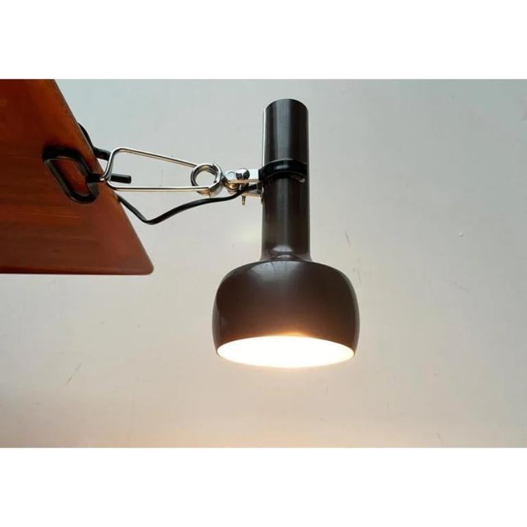 Lampes de serrage simples de l'ère spatiale de Swisslamps.

Un design minimaliste. La tête de projecteur classique de Swisslamps est conçue dans un ton brun et fixée dans un clip à ressort. La tête est réglable grâce à une articulation à rotule. La