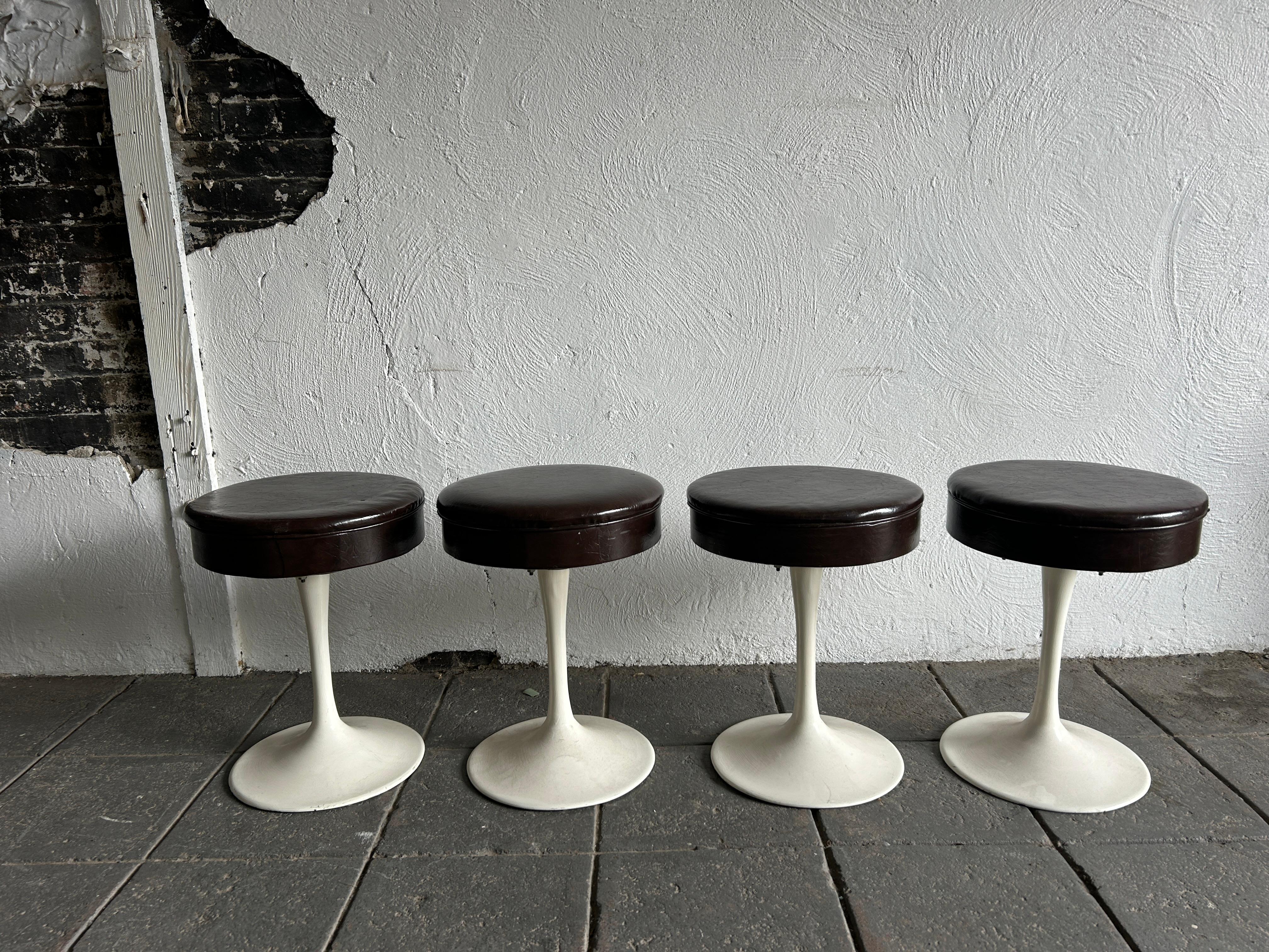 Set of 4 mid century tulip swivel stools style of Knoll. Great vintage set with metal tapered bases and rotating brown vinyl upholstery. Great solid set. Located in Brooklyn nyc. 

Sold as a set of 4 

Each stool measures 18” high x 14” diameter 