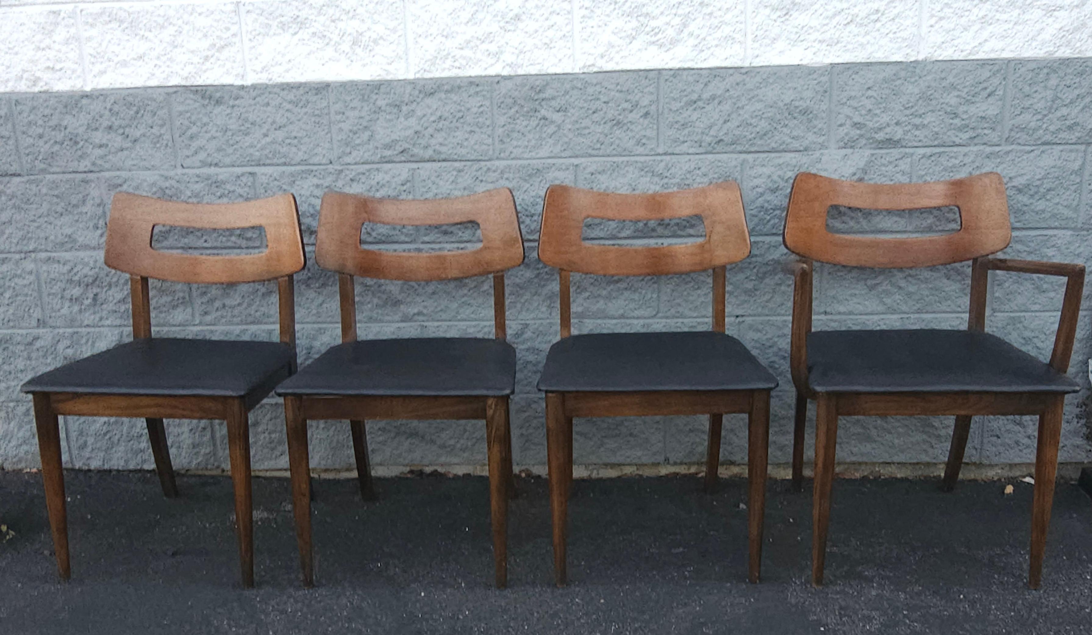 Set of 4 Mid Century Walnut and Vinyl Seat Upholstered Chairs. Very good vintage condition. Solid mid century vinyl seats in great shape. Three side chairs and one arm chair. 

Measures 19