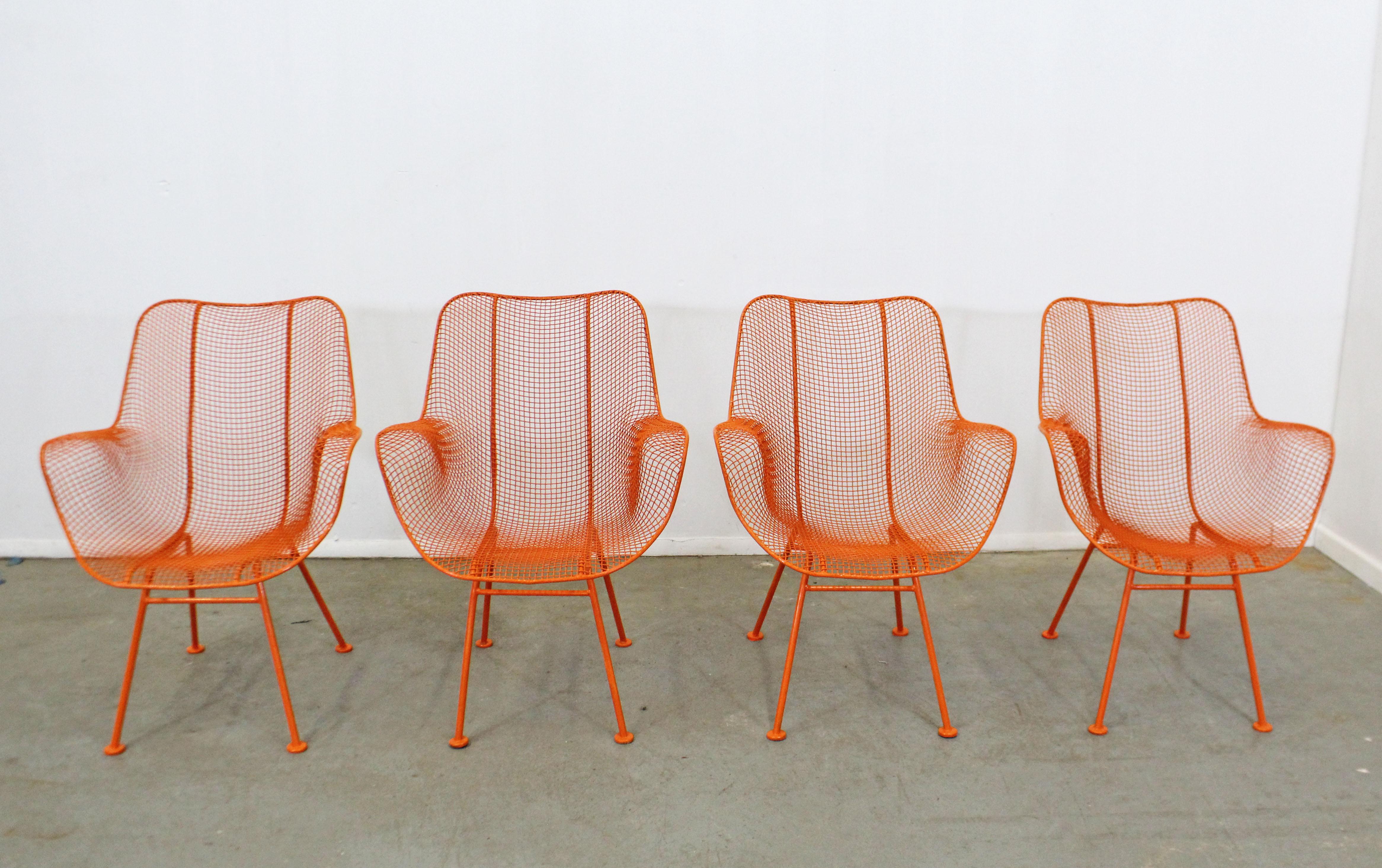 What a find. Offered is a set of 4 Mid-Century Modern outdoor armchairs designed by John Woodard, circa 1956 for the 'Sculptura' line. Features enameled and woven wrought iron. The chairs are structurally sound in very good condition with orange