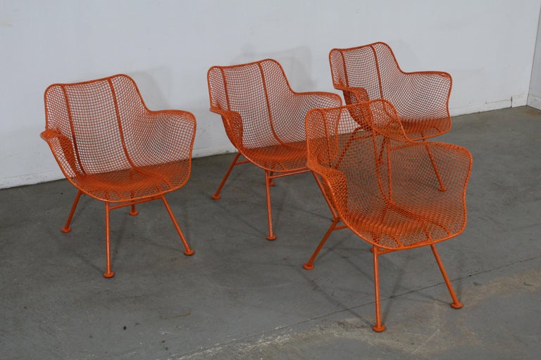 What a find. Offered is a set of 4 Mid-Century Modern outdoor armchairs designed by John Woodard, circa 1956 for the 'Sculptura' line. Features enameled and woven wrought iron. The chairs are structurally sound in very good condition with orange