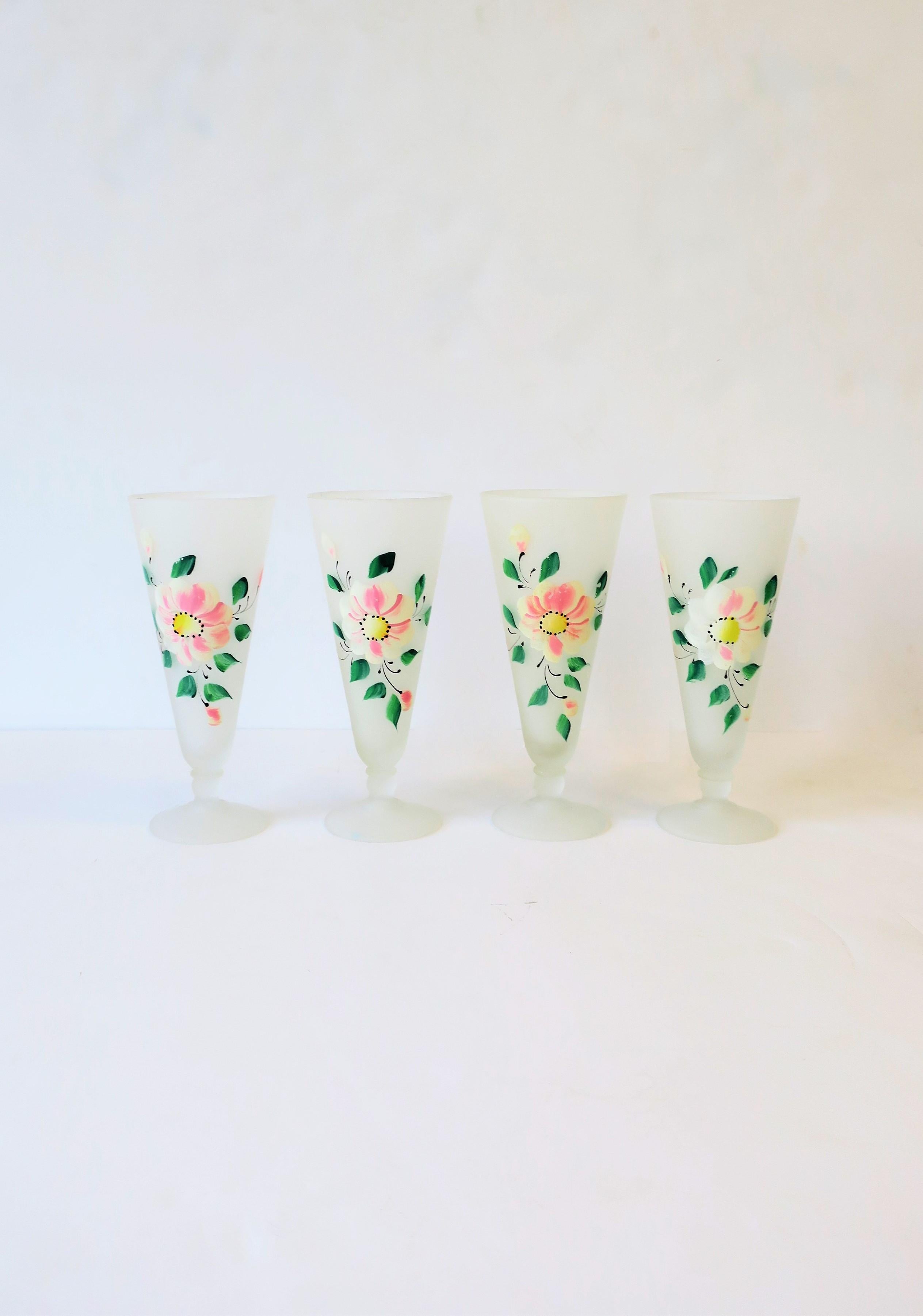 A beautiful set of four (4) white cocktail glasses with a hand painted floral 'chintz' design of large main flower, flower buds, and leaves, circa mid-20th century, USA. Colors include white, pink, yellow, green and a touch of black. A great