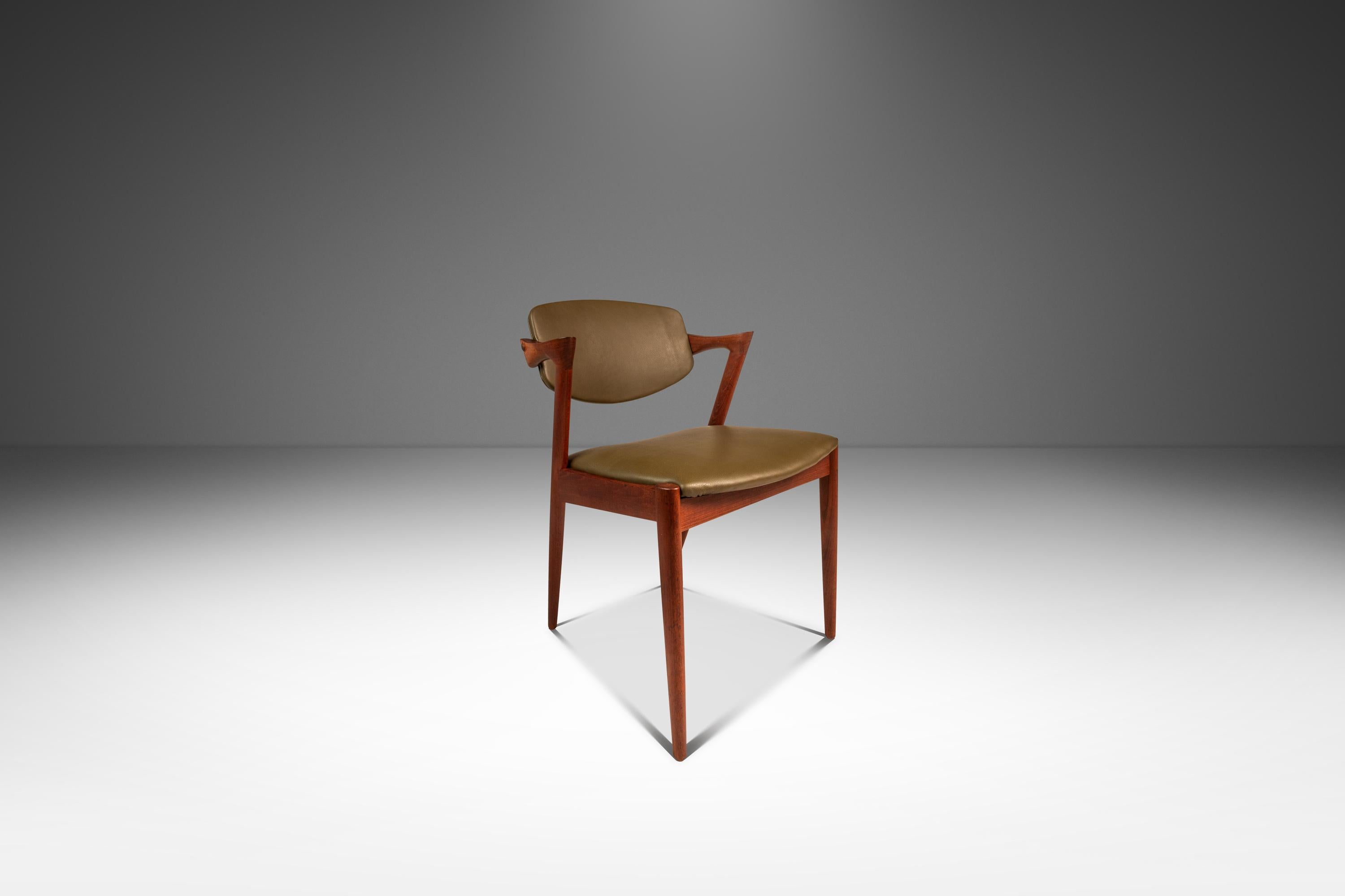 Dieses elegante Set aus vier Model 42 Esszimmerstühlen, entworfen von Kai Kristiansen, zeigt die zeitlose Raffinesse des dänischen Designs der Jahrhundertmitte. Die Stühle sind aus massivem Teakholz mit einer warmen, natürlichen Oberfläche gefertigt
