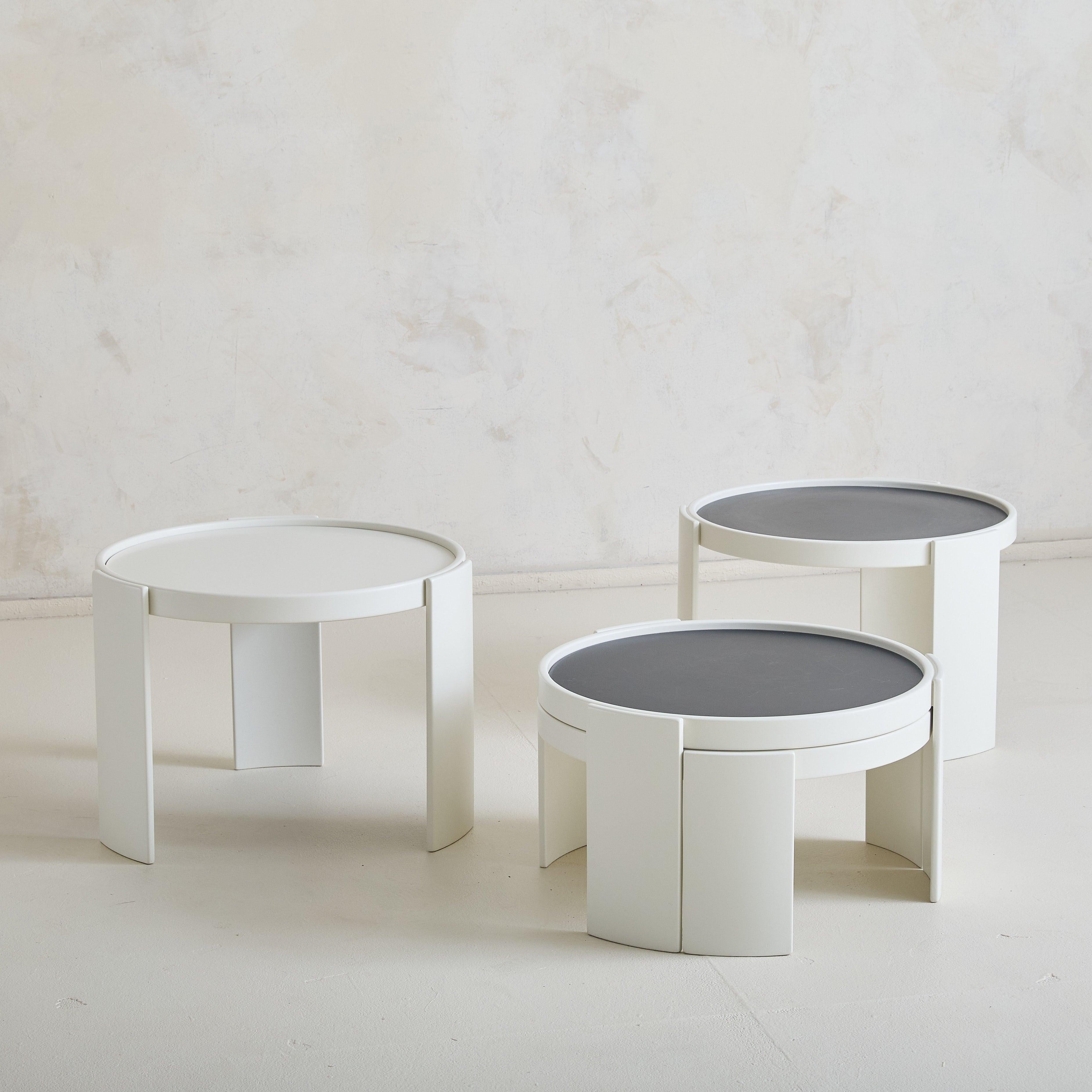 A set of 4 ‘Model 780’ modular nesting tables designed by Gianfranco Frattini for Cassina in 1966. Crafted from solid wood in a white finish, these side tables feature laminated tops with reversible black and white sides, providing an element of
