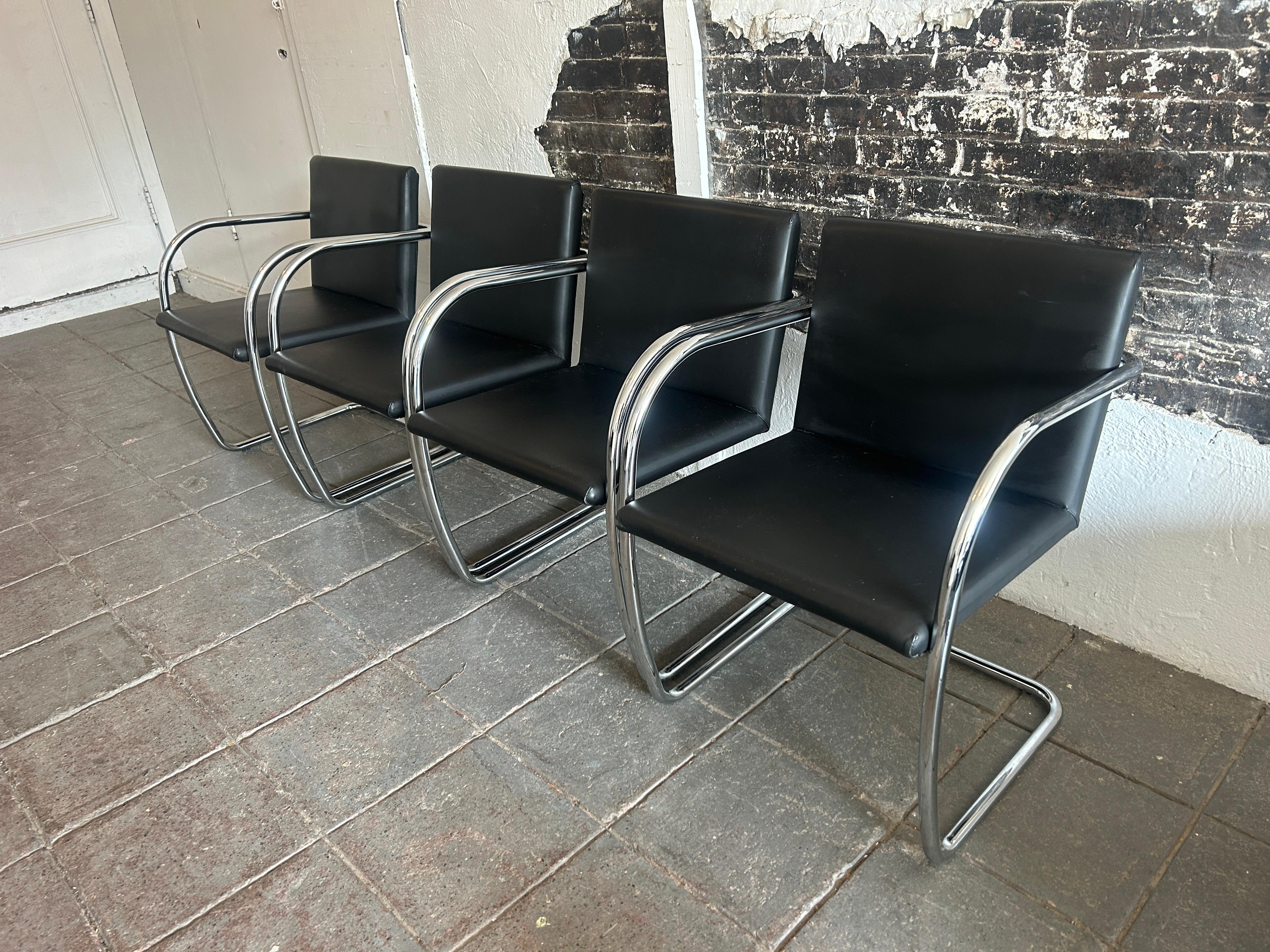 Set of 4 modern black leather Brno chrome tube chairs. Chrome tubular bent frame with soft black leather upholstery. classic modern design by Ludwig Mies van der Rohe. Great for us as dining chairs or office chairs.- Labeled Made in Italy

Sold as a