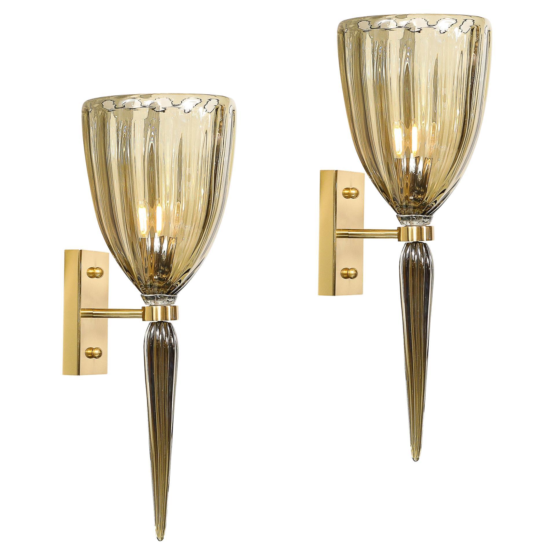 This dazzling set of 4 modernist Murano glass sconces showcases the finest in Venetian glass artistry, rendered in Italy during the 21st Century. Each sconce is meticulously hand-blown and features a stunning fluted glass design in a captivating