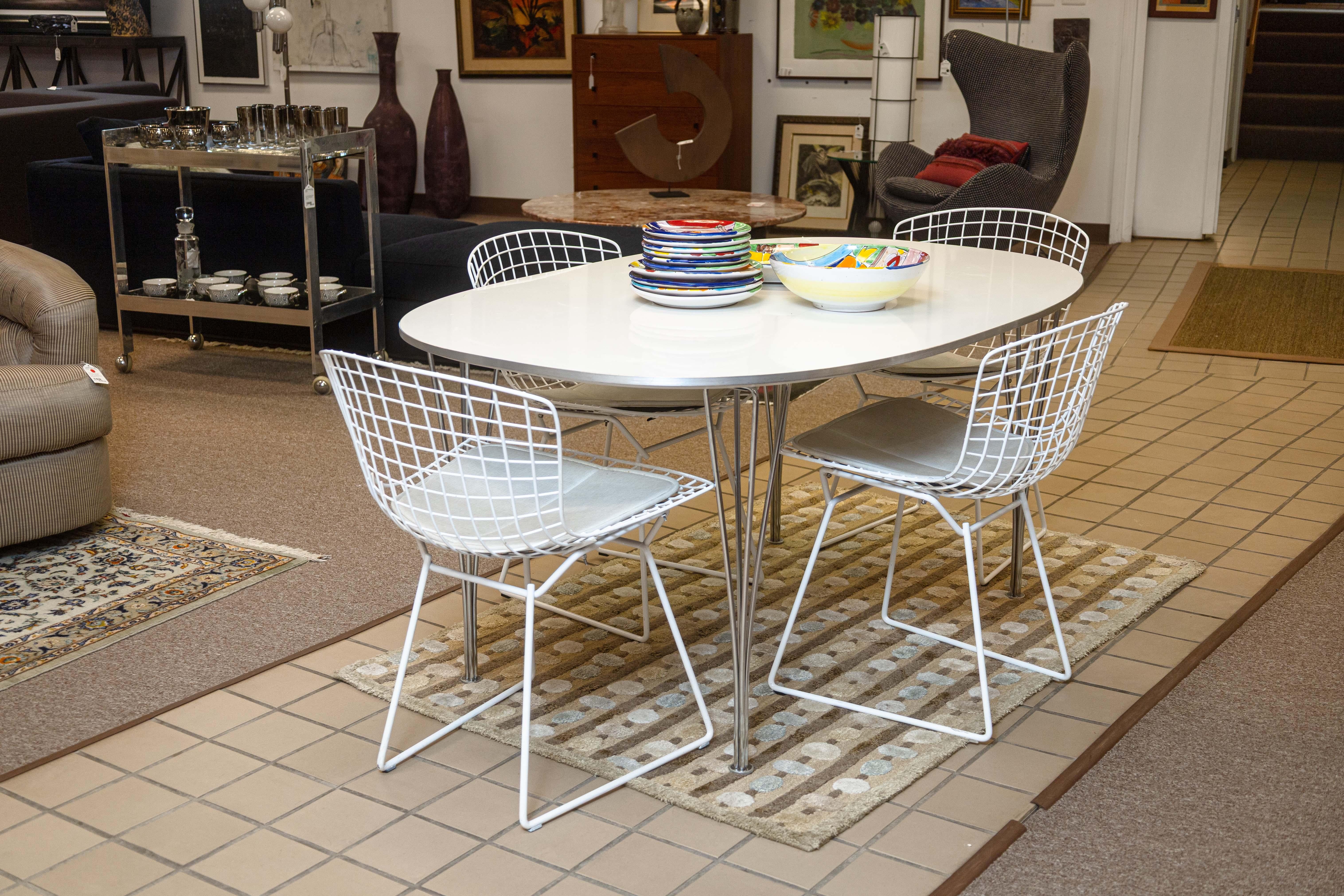 A set of 4 Harry Bertoia side chairs. This is a set of 4 contemporary modern Bertoia side chairs. Each of these chairs are made with a white steel wire frame, a timeless design that was a staple of the mid century modern era, and have continued to