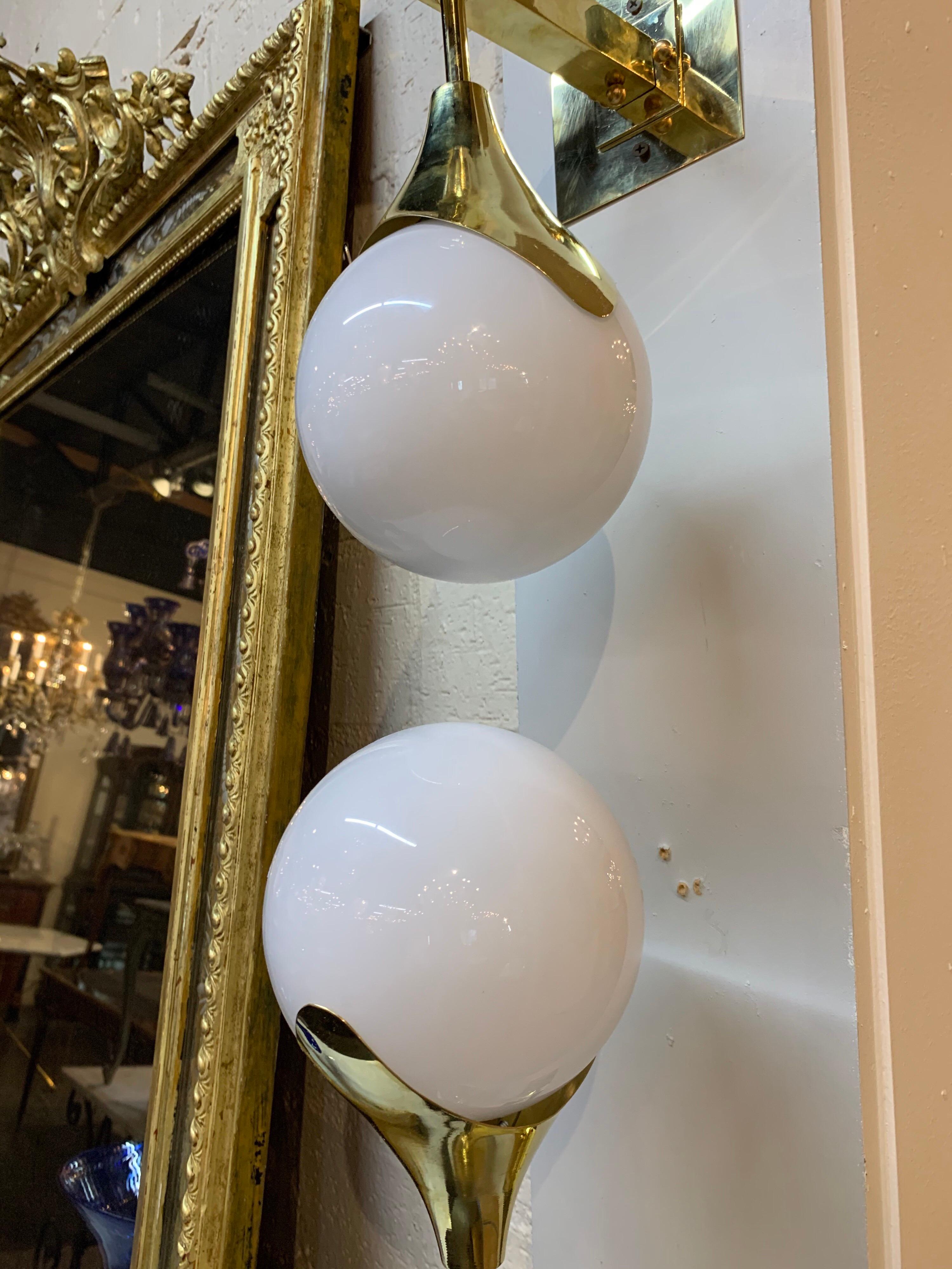 Very sleek set of 4 modern gilt brass and Murano glass sconces. Each sconce has 2 glass balls on a shining brass base. A lovely choice for a contemporary setting.