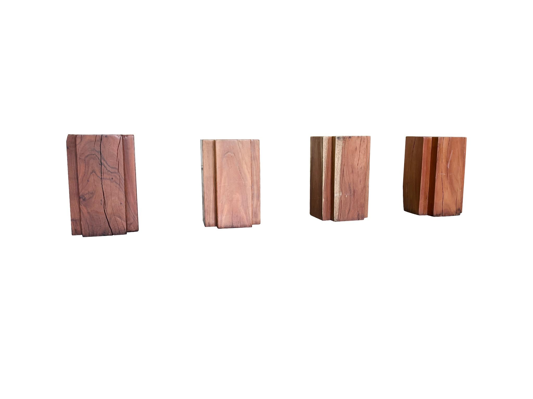 Vintage set of four Modern cruciform pedestal side tables or stools. They are solid teak with substantial weight. We love the wood's rich, warm tone and beautifully aged surfaces.

Dimensions:
11.25 in. width
11.25 in. depth
18 in. height

Condition