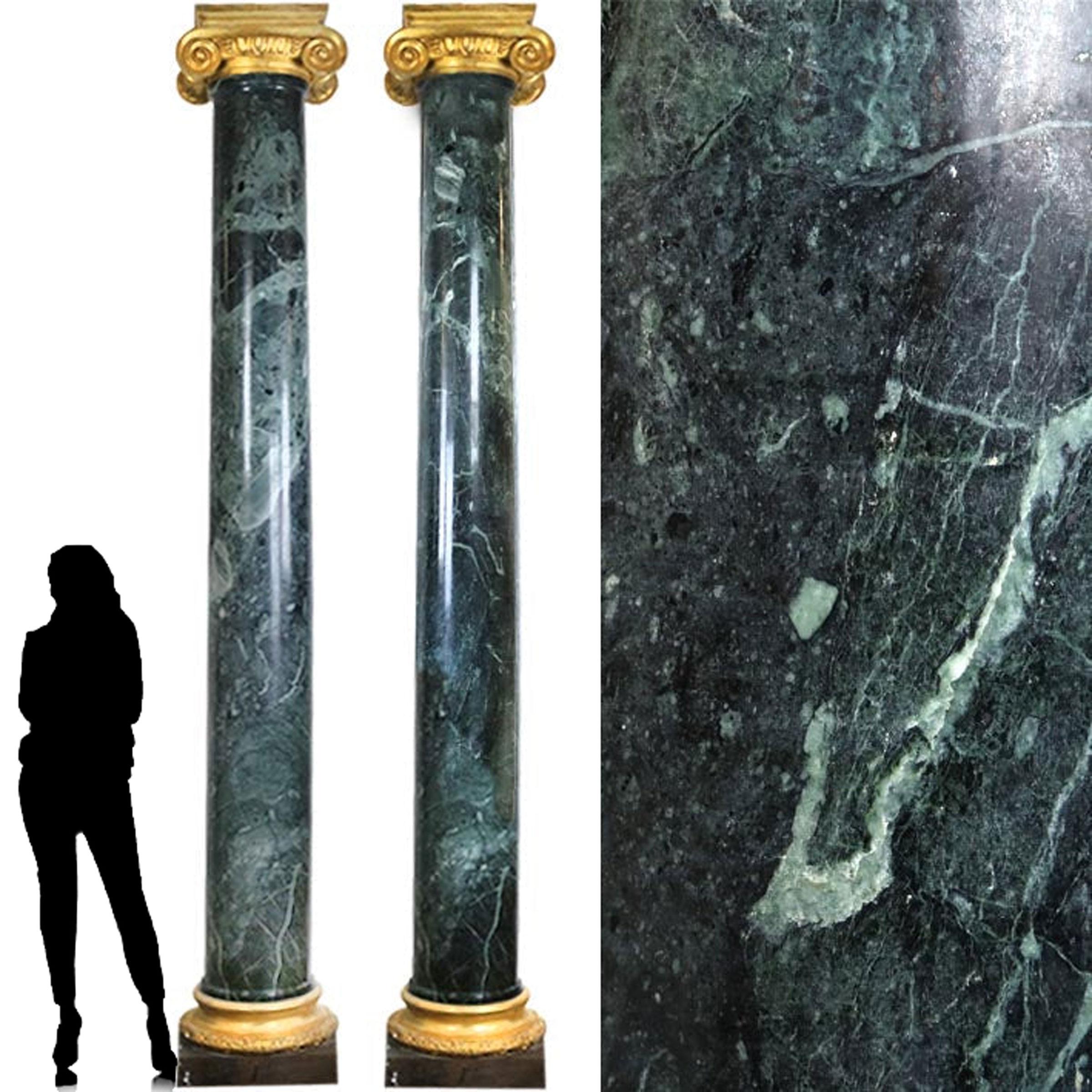 A spectacular pair of green marble columns with steel and gilded bases and capitals.

Leaf garland, egg and dart borders and scrolls adorn the capitals and base of these substantial pillars. 

Wonderfully veined and dappled verde marble. The grand