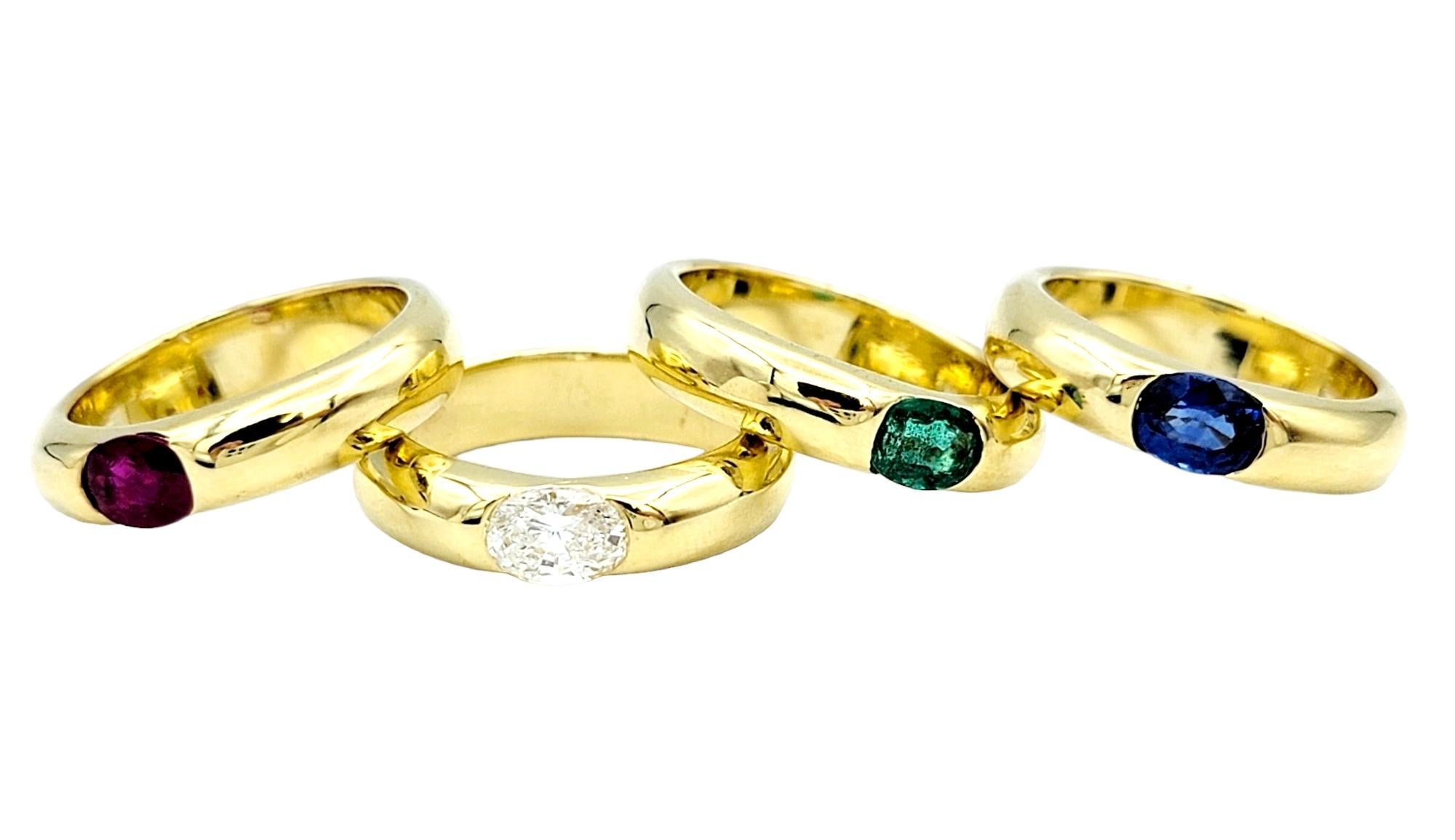 Ring Sizes: 4.5, 4.75 and 5

Indulge in the allure of vibrant gemstones with this exquisite set of four 18 karat yellow gold stacking band rings, each adorned with a unique oval-shaped gemstone at its center. Individually unique, yet harmoniously
