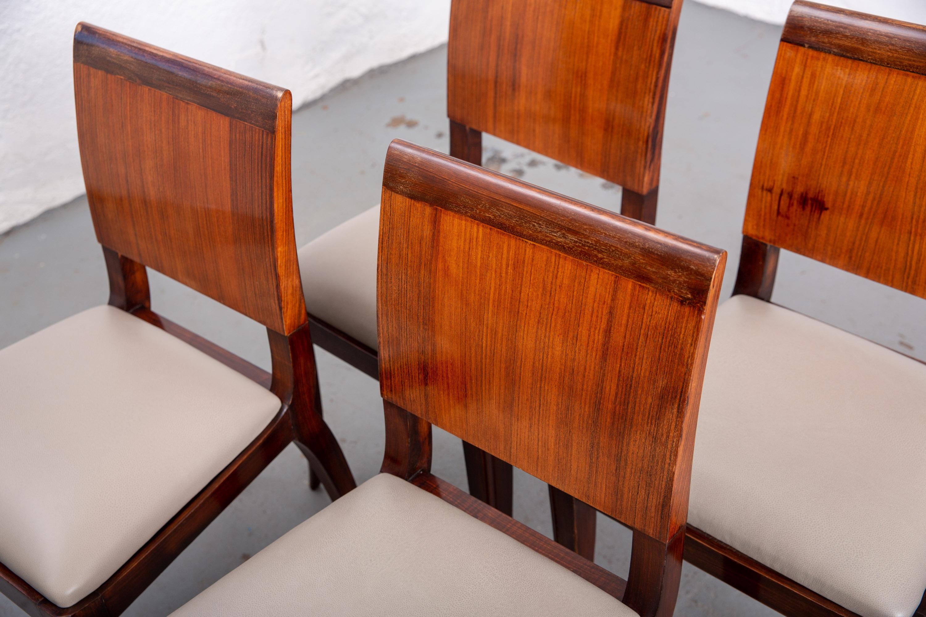 Set of 4 beautiful Art Deco dining chairs with solid panel back and curved and tapered legs. Newly upholstered in high quality leather. Sturdy. Original condition with great age to wood.