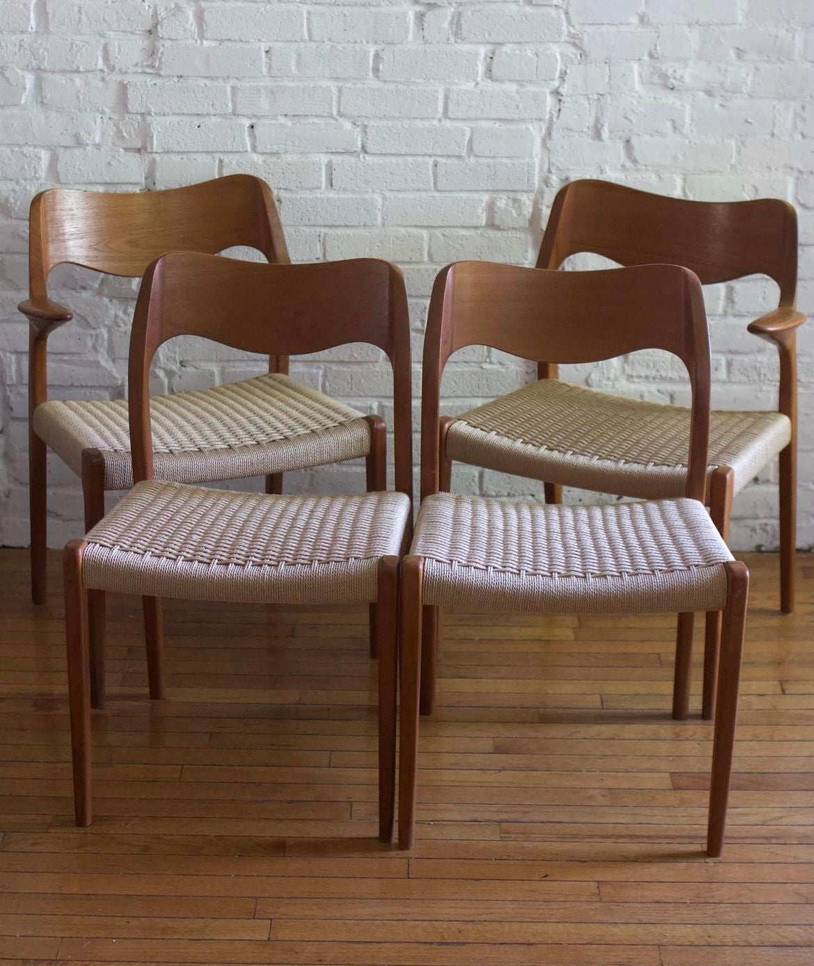 A fantastic set of 4 Niels O. Møller dining chairs - including two Model 71 chairs and two highly sought-after matching Model 55 captains chairs. Sculptural hardwood teak frame and Danish cord seats. New Danish cord was just completed. 

Made in