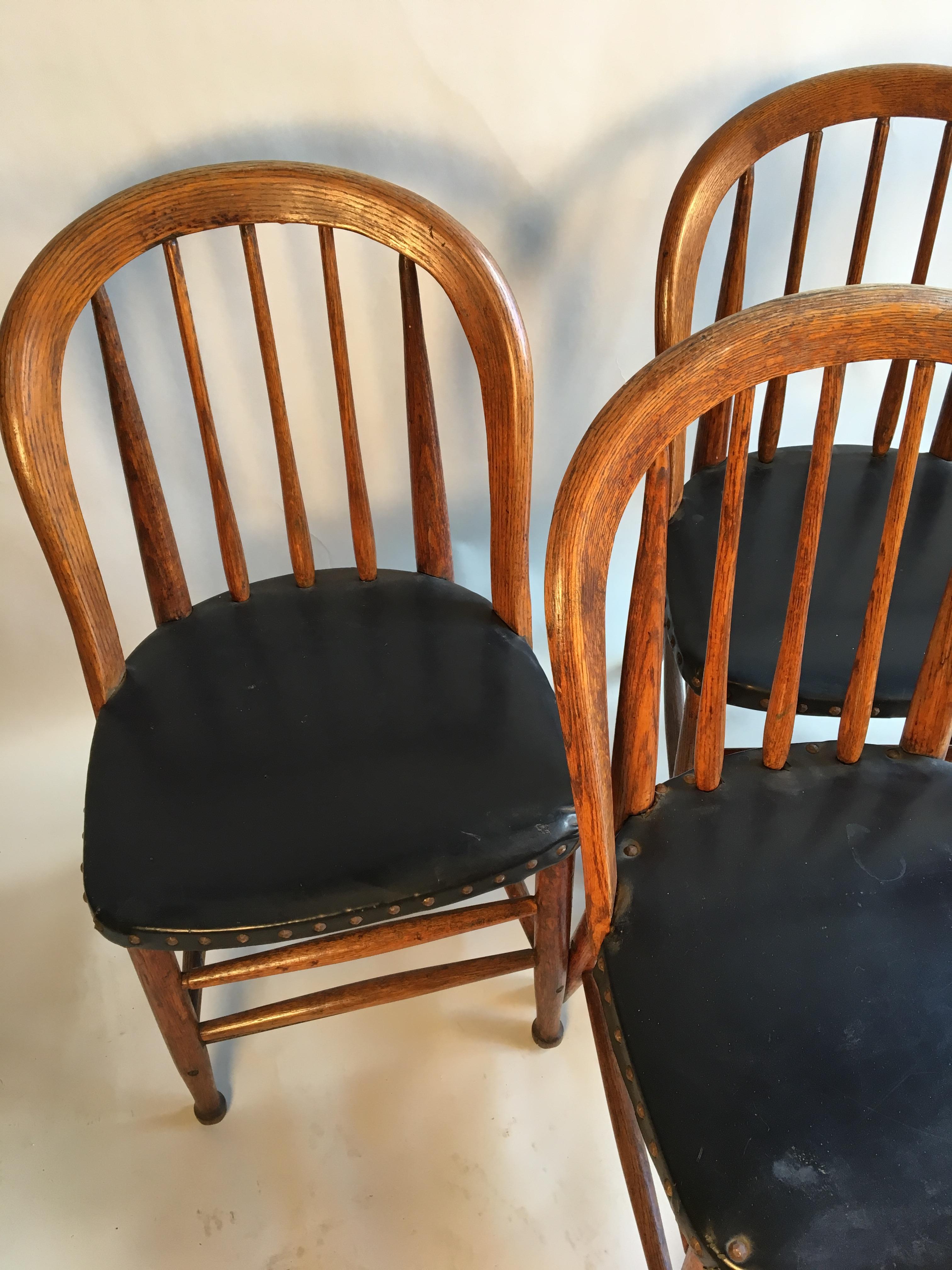 A set of 4 oak barrel-back chairs with black vinyl seats, circa 1880, American.