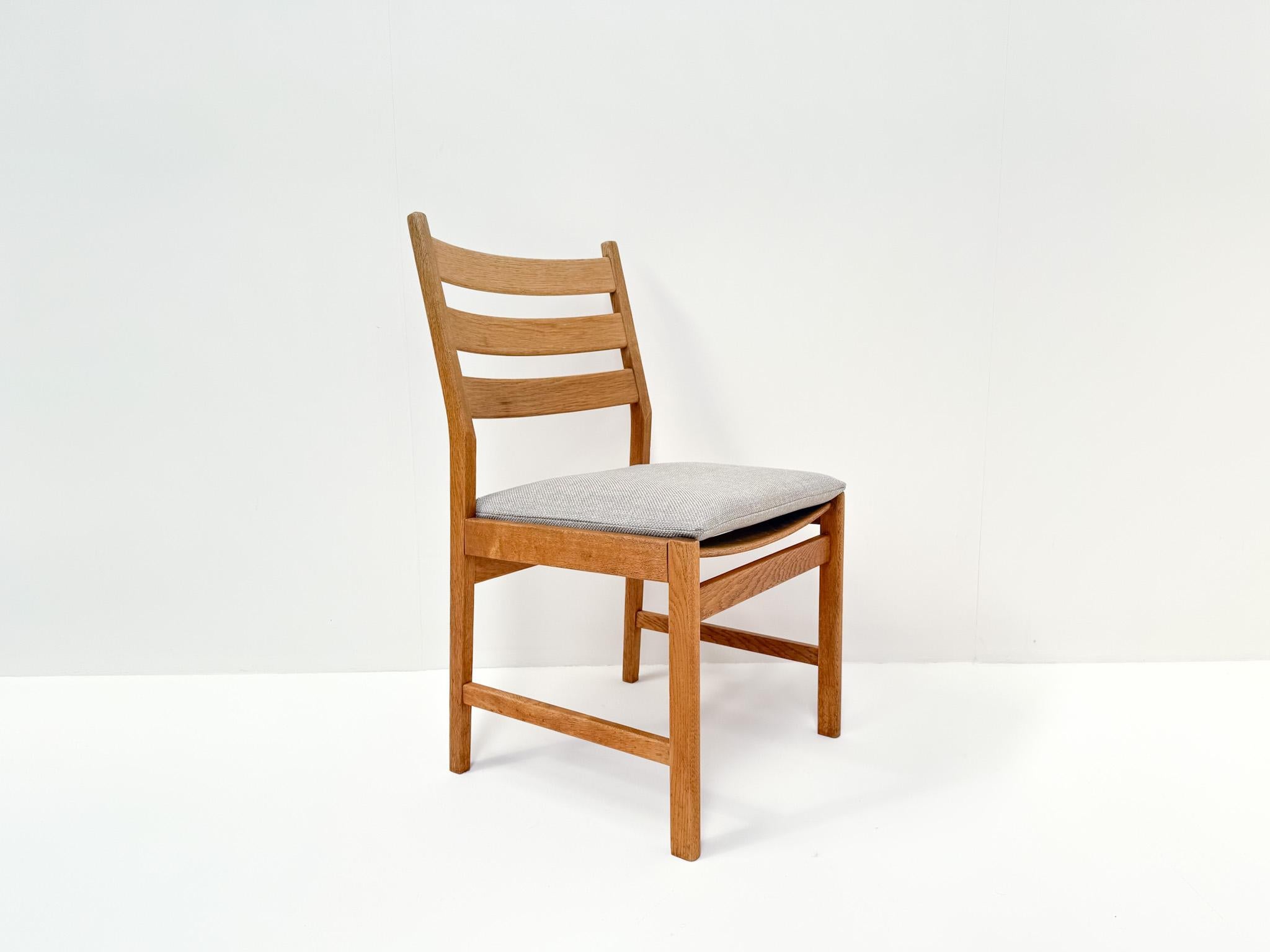 This beautiful set of four dining chairs was designed by Kurt Østervig and made in Denmark. The frames are crafted from solid oak, highlighting elegant Scandinavian lines and high-quality craftsmanship. The seats are newly upholstered in light grey
