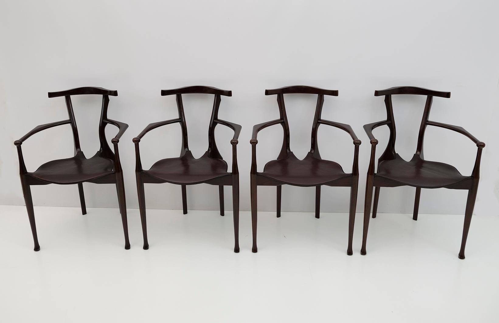 Set of four Gaulino chairs designed in 1987 by Oscar Tusquets in homage to the works of Gaudí and Carlo Mollino. First edition for Carlos Jané in mahogany stained oak and leather seats.