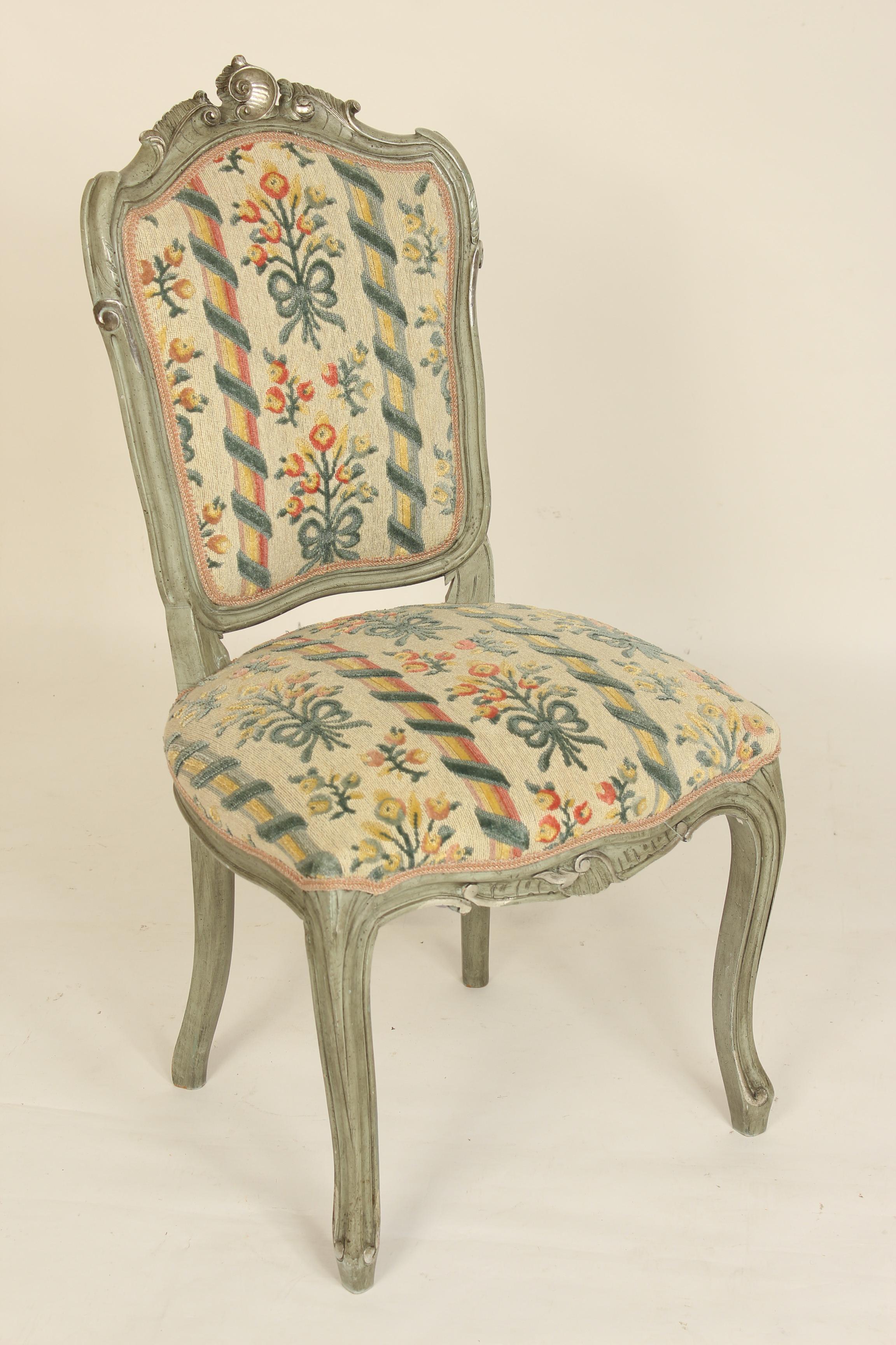 Set of 4 grayish green painted Louis XV style side chairs with silver highlights, circa late 20th century. Embroidered type upholstery with slightly raised areas.