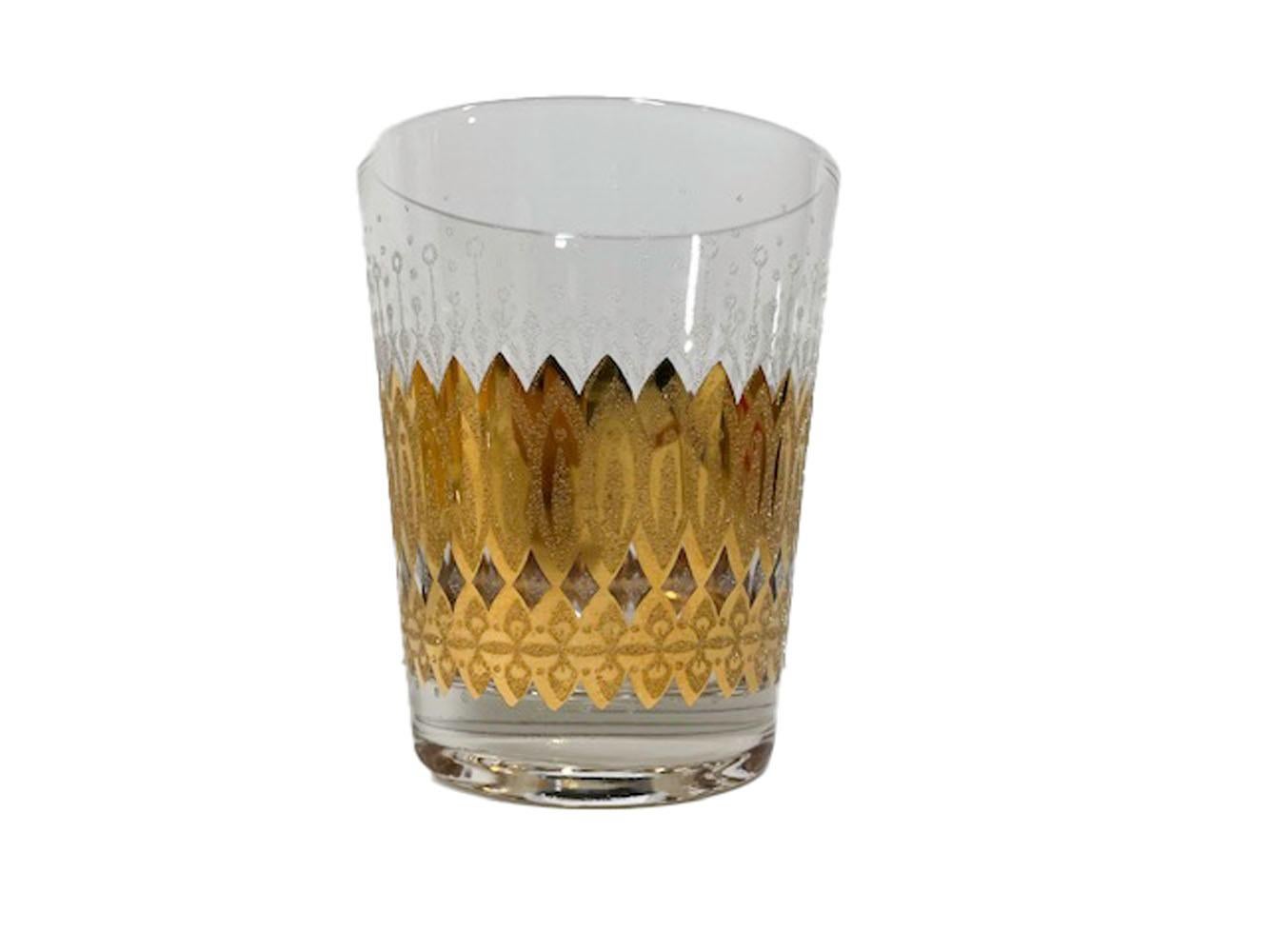 Four Mid-Century Modern double old fashioned glasses designed by Irene Pasinski. Decorated in 22k gold with raised 'sugared' patterns below stylized floral motifs in clear 'sugared' frosted enamel.