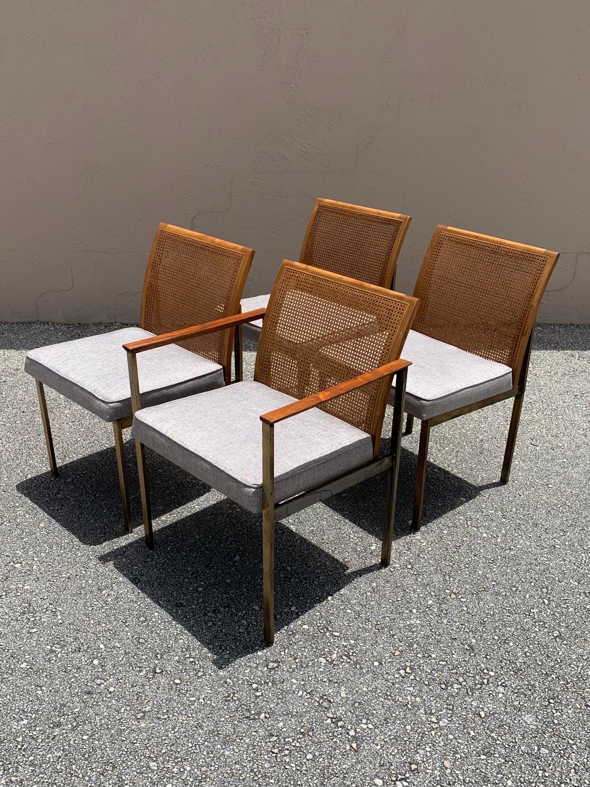Set of 4 unique dining chairs made by Lane Furniture. Often attributed to Paul McCobb due to the simple yet elegant design. Clean lines through the metal frames working up to the wood and cane backrests. 4 total chairs. One captain chair and 3 side