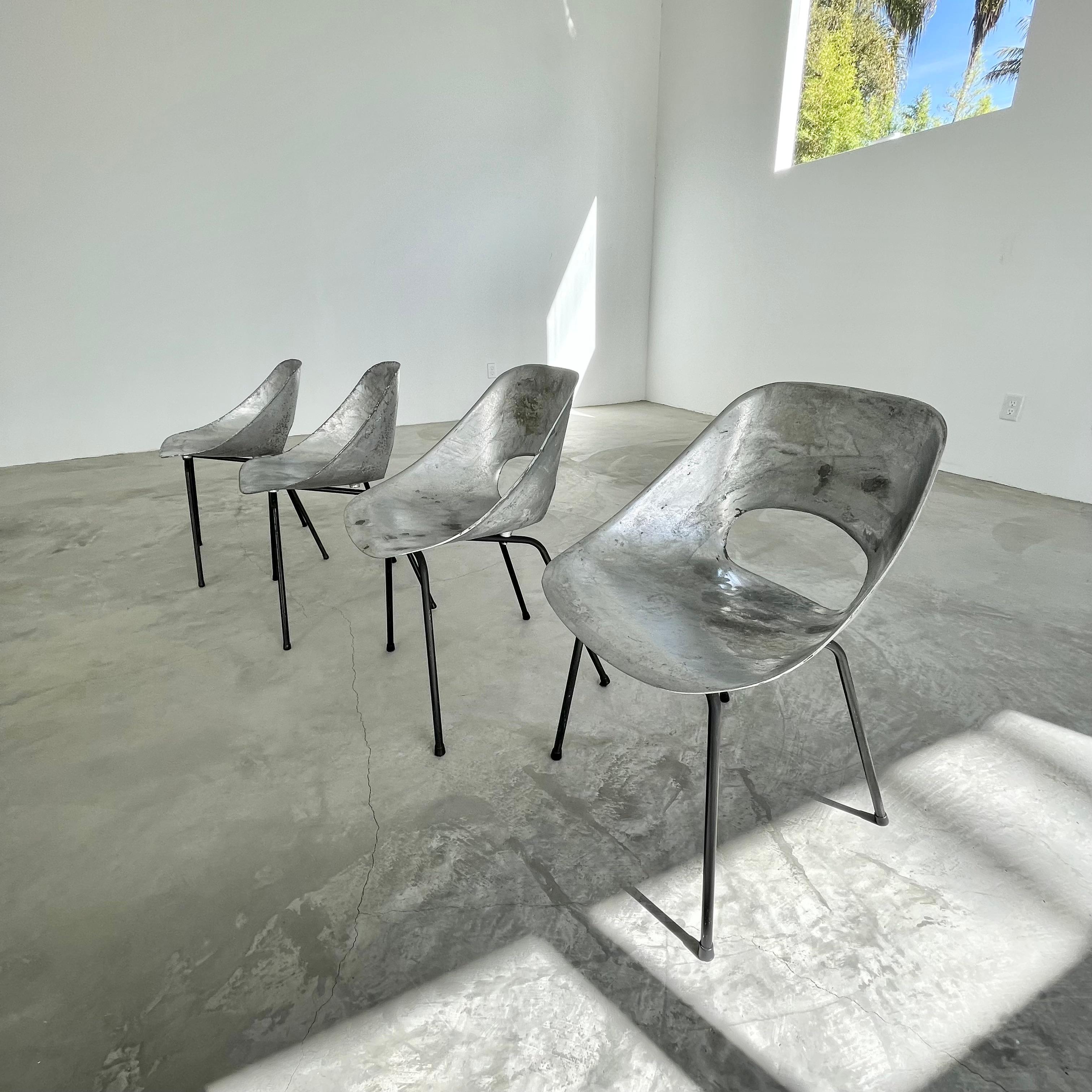 Gorgeous set of 4 aluminum chairs by Pierre Guariche. Cast aluminum frame sits on four iron legs. Great vintage condition and beautifully minimal design. Extremely rare. The non conventional beauty of these chairs makes them a great standalone
