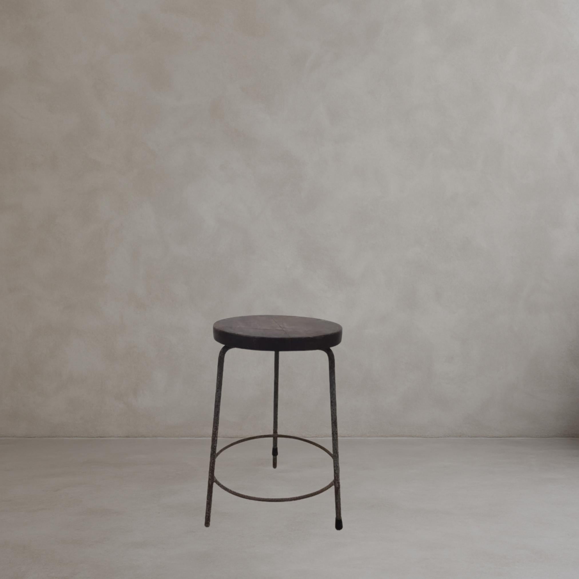 Authentique ensemble de 4 tabourets Pierre Jeanneret en teck massif et fer soudé, avec une base tripode ronde caractéristique et une assise subtilement concave. Un tabouret porte la marque A.S.R. 89.

- Dimensions : Hauteur 22 pouces / 55cm 