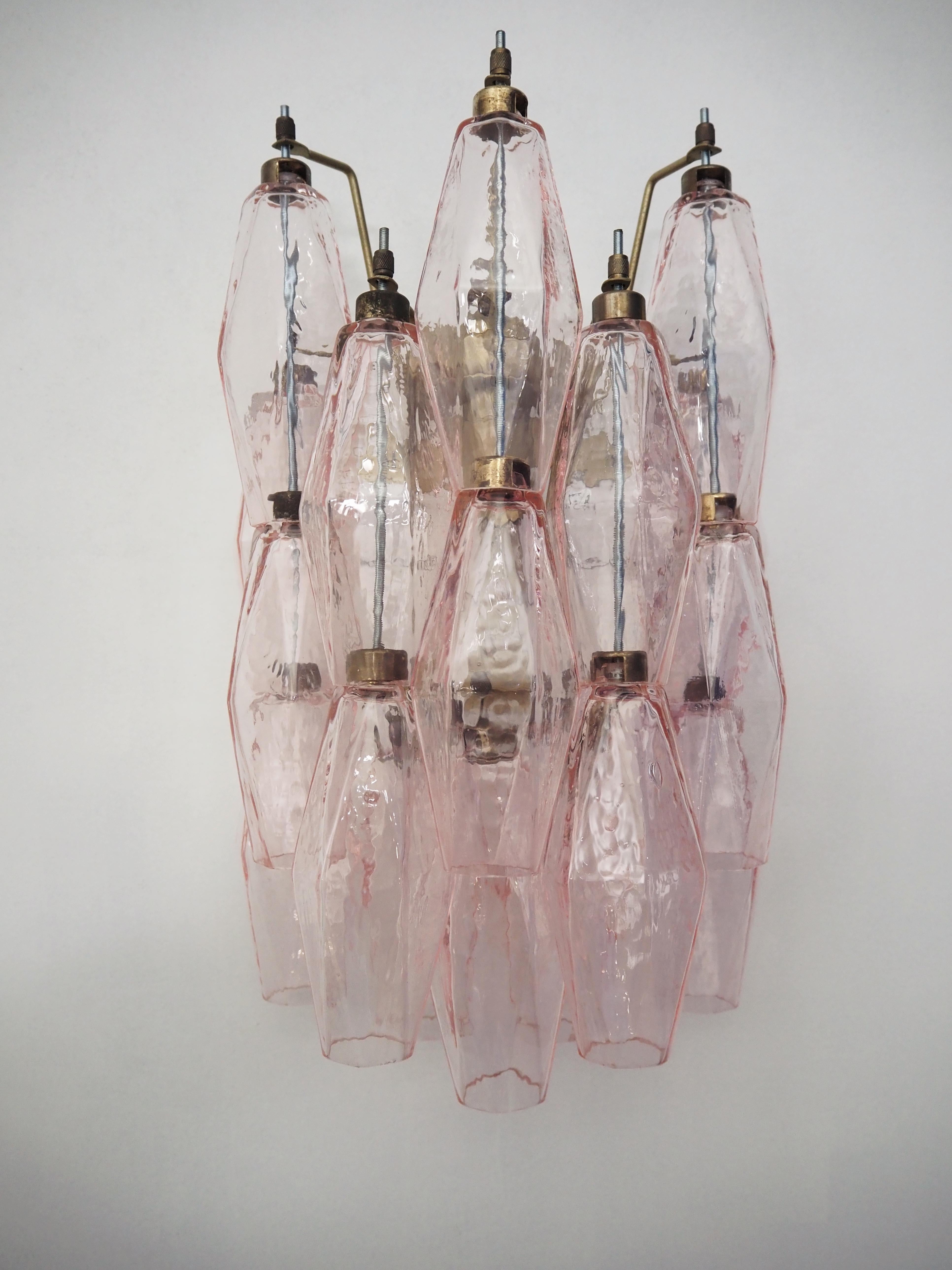 Pair of Pink Murano Wall Lamps consisting of 17 handmade crystal prisms in pastel pink colored murano glass. Lamp structure of metal with fittings painted in a light brown, bronzy tone. Glass from the Italian Murano District. Traditional Italian