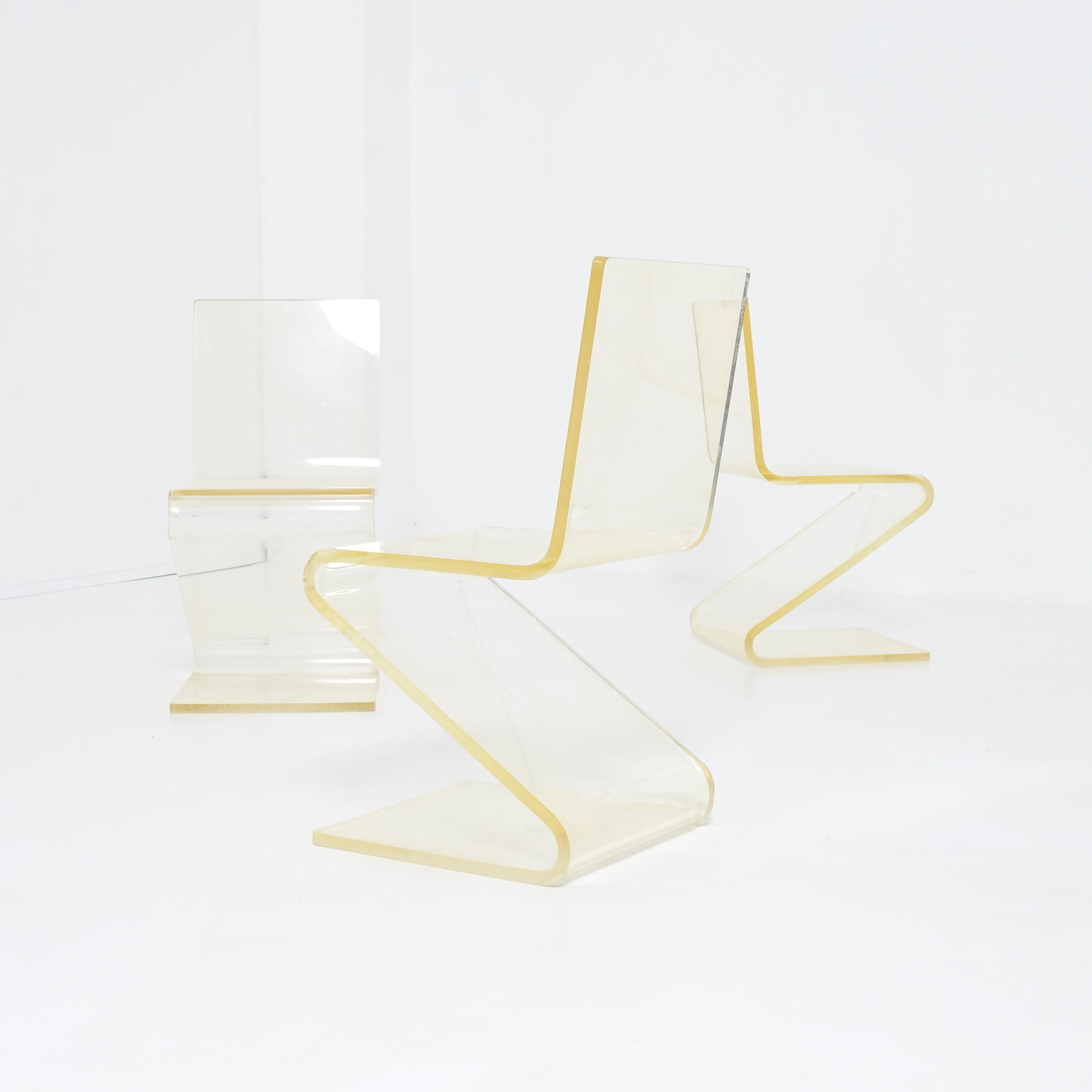 These Zig Zag chairs were designed and produced in the 1960s. After more than 60 years of use, they are still in good vintage condition. The transparent yellow plexiglass or perspex has been used intensively, resulting in many scratches. The