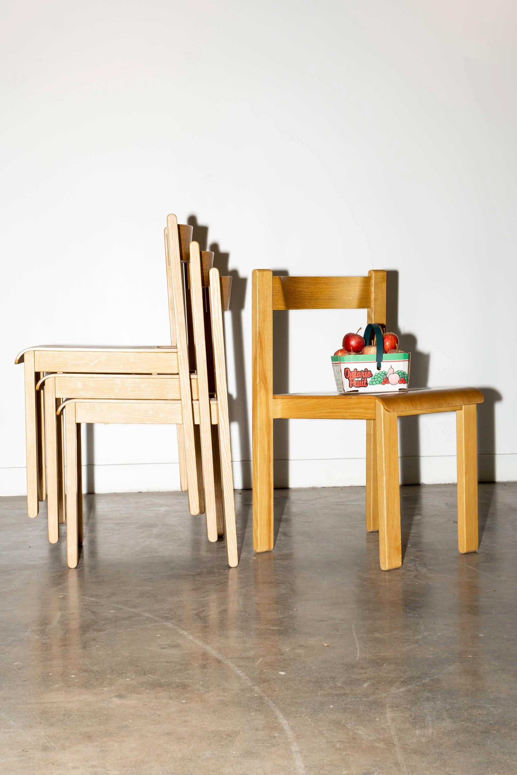 Un ensemble de 4 chaises simples et empilables en contreplaqué du designer Vico Magistretti. A utiliser comme bureau et chaises d'appoint, ou comme ensemble de salle à manger. Cool mais pas trop pour l'école.
