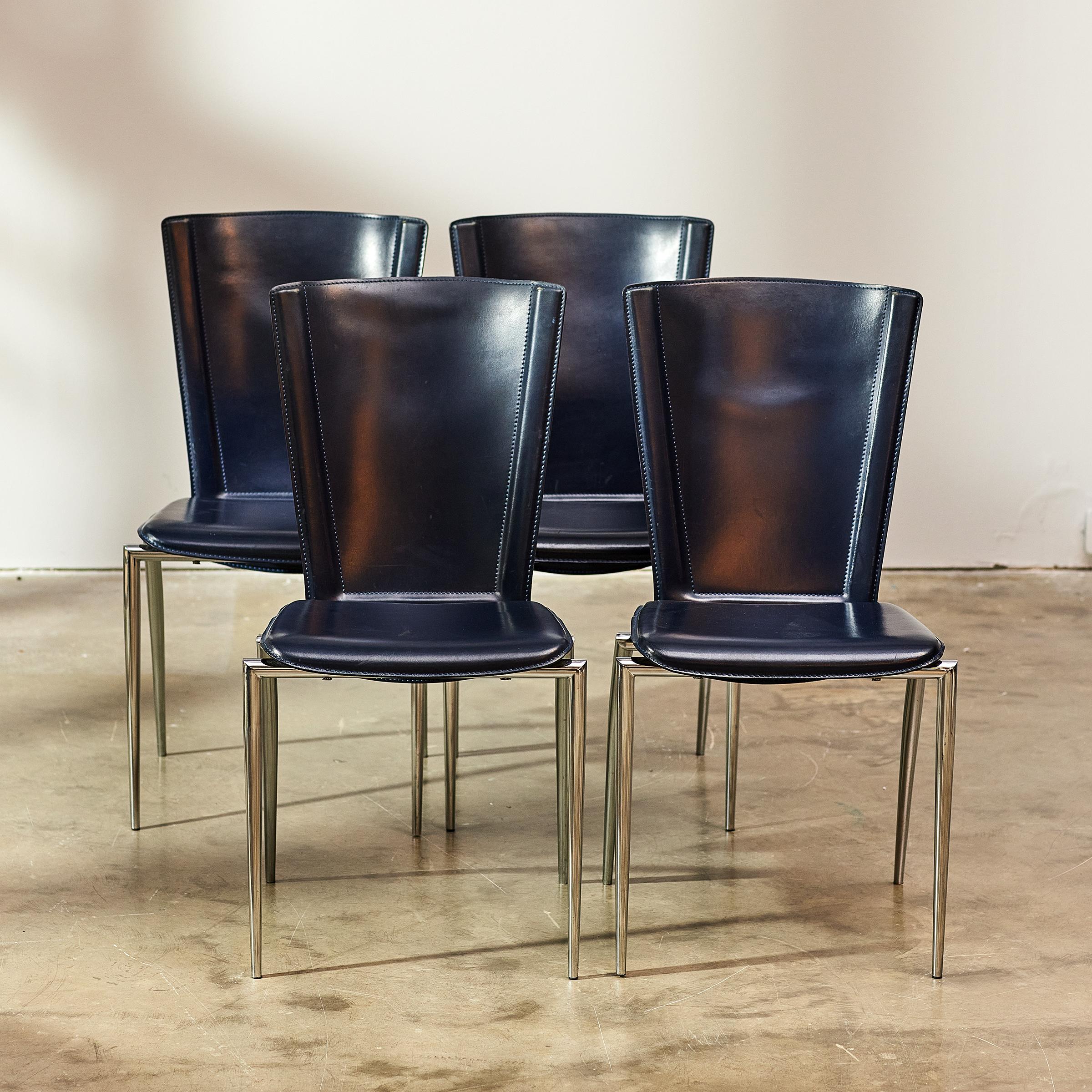 These four 1980s Italian depp blue leather dining chairs by Frag feature an exquisite postmodern design—with a slender back, tapered legs and a unique floating ergonomic seat.

