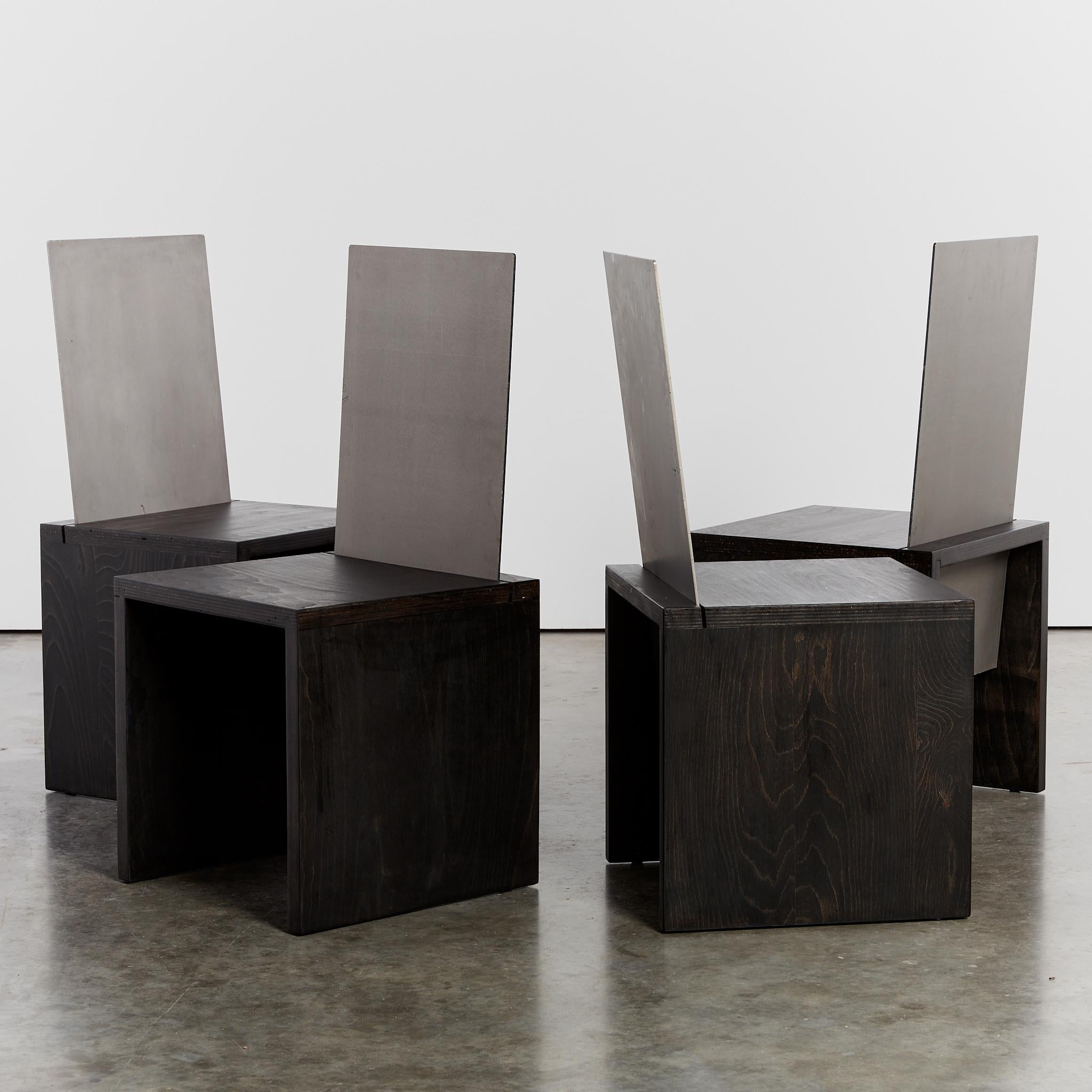 Set of four solid steel back chairs, with ebonised ply bases. With a silhouette reminiscent of Donald Judd's Chair 84, each chair features a 5mm steel back, that cuts through the ebonised base.

Sold as a set of 4.

Designer: No attribution,