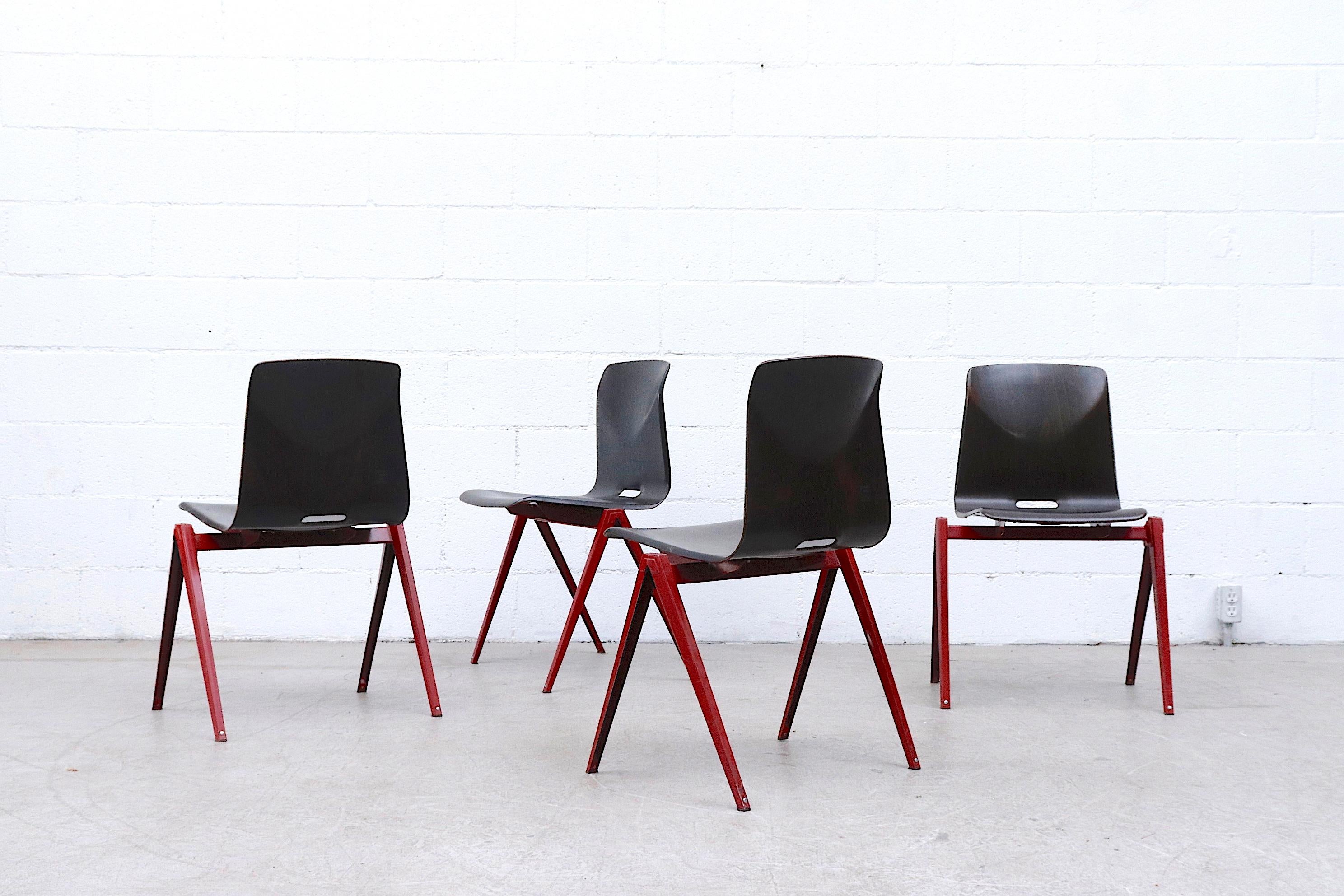 Set of 4 midcentury Prouve style stacking chairs with dark red enameled metal legs and Wenge toned bent ply-laminate shell seat. In original condition with some frame wear and visible scratching on seat. Wear is consistent with their age and use.