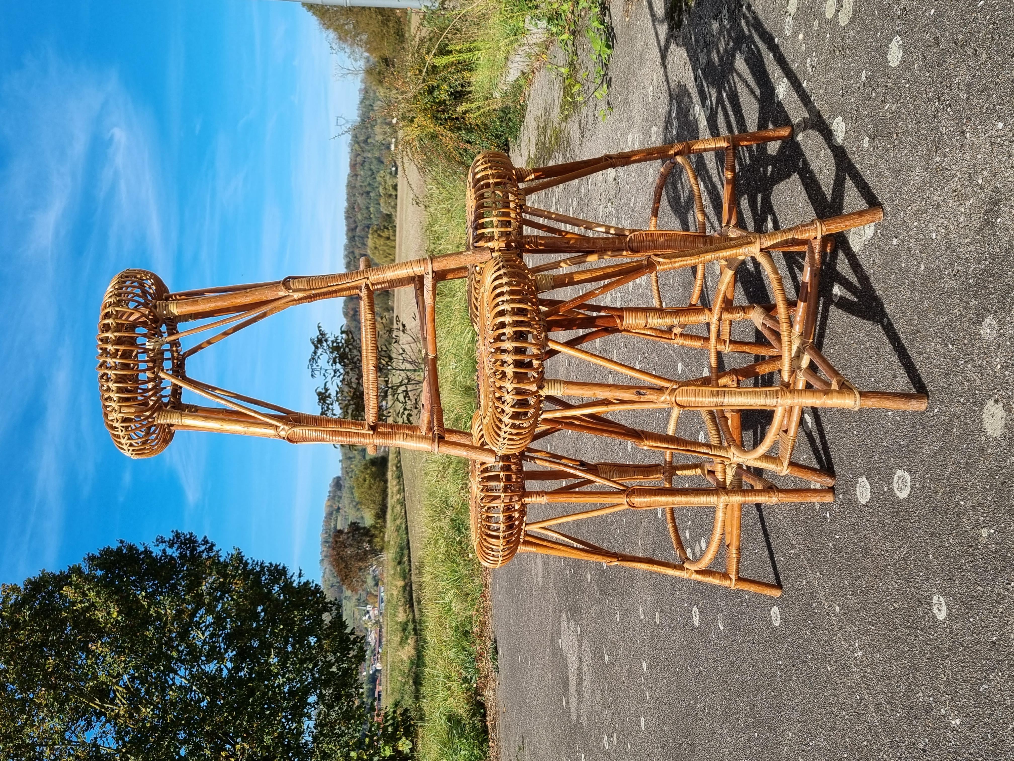 Set of 4 bar stools in wood and rattan by Franco Albini, in 1950. The structure of the stools is in wood and the seat in curved rattan. in very good condition. Some traces of time. Dimensions: 77cm high X 55cm diameter at the feet and 42cm diameter