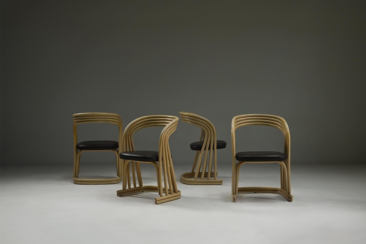 Satz von 4 Rattan-Esszimmerstühlen, 1980er Jahre Italien. Gebogenes, cremefarbenes Rattan bildet den skulpturalen, organischen Rahmen und die Rückenlehne eines jeden Stuhls. Die Sitze sind mit dunkelbraunem Leder gepolstert und mit eleganten