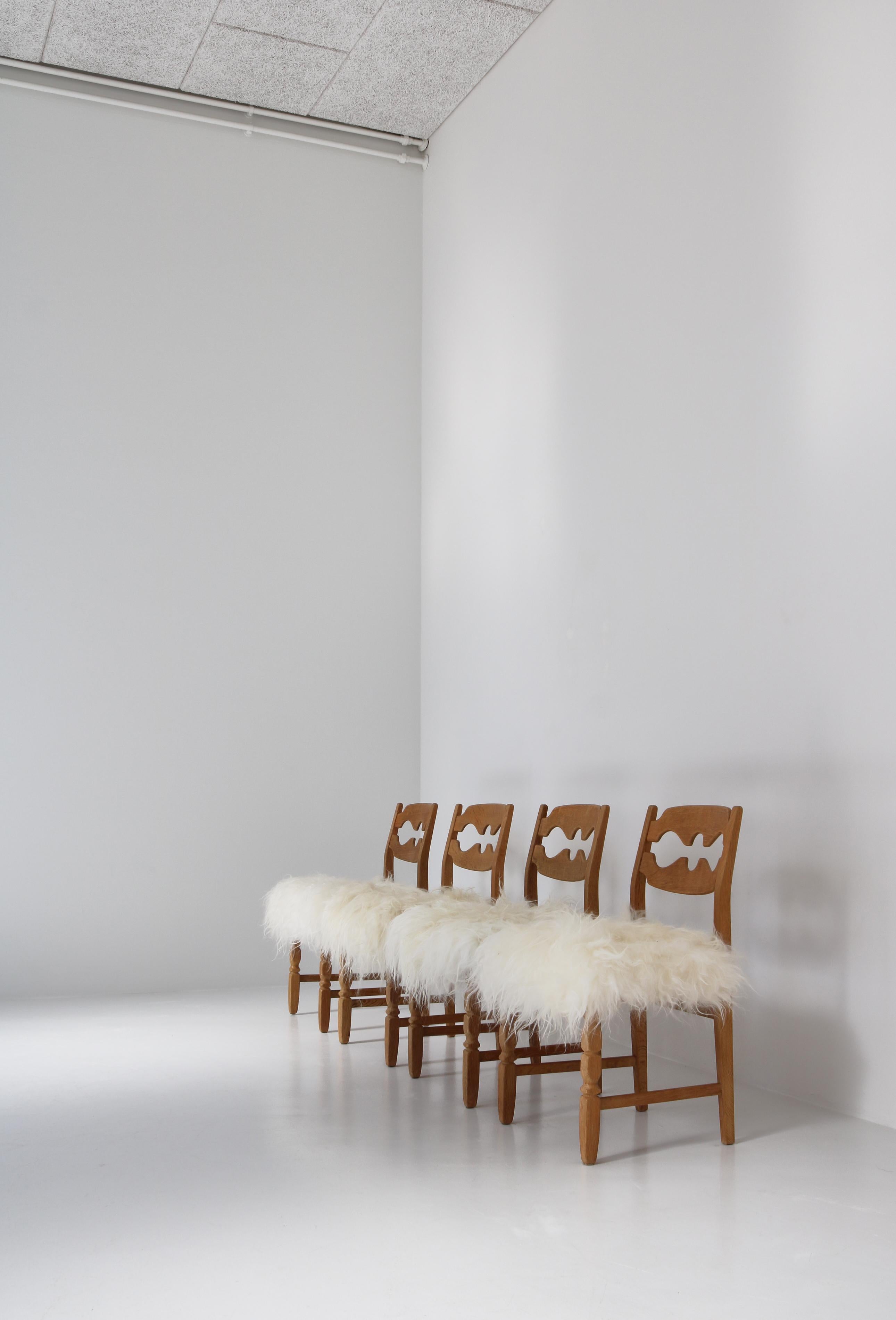 4 Stühle aus massiver, patinierter, quartiersgesägter skandinavischer Eiche, gepolstert mit langhaarigem Bio-Schafsfell aus Gotland. Ein sehr beeindruckendes Set in gutem Zustand. Dieses Modell wurde in den 1960er Jahren vom dänischen Designer Henry