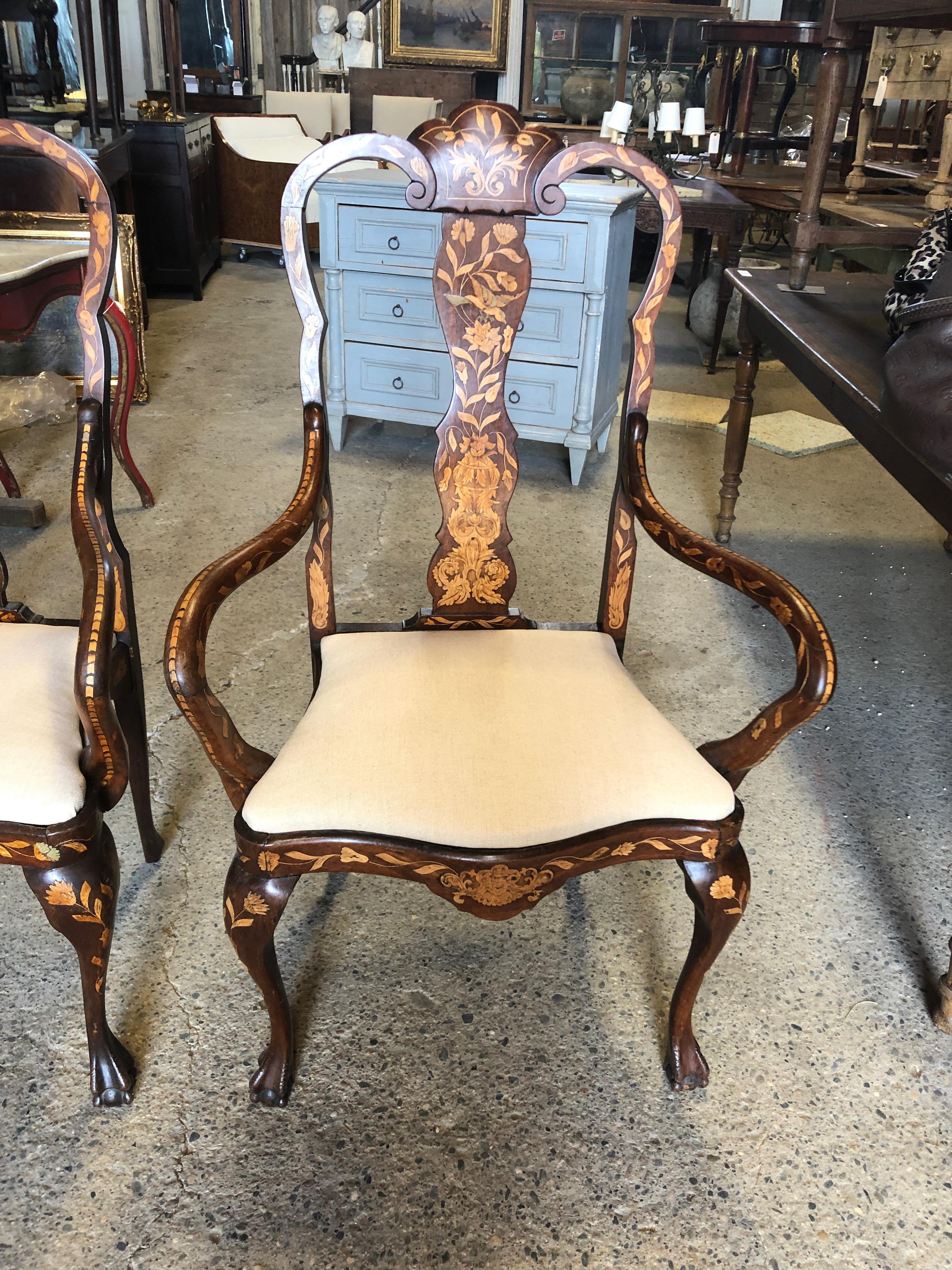 A set of four exquisite Dutch dining chairs consisting of two armchairs and two sidechairs, having the most amazing decorative inlay marquetry. The armchairs are not inlaid on the backs, but the side chairs are decorative front and back. Arm height