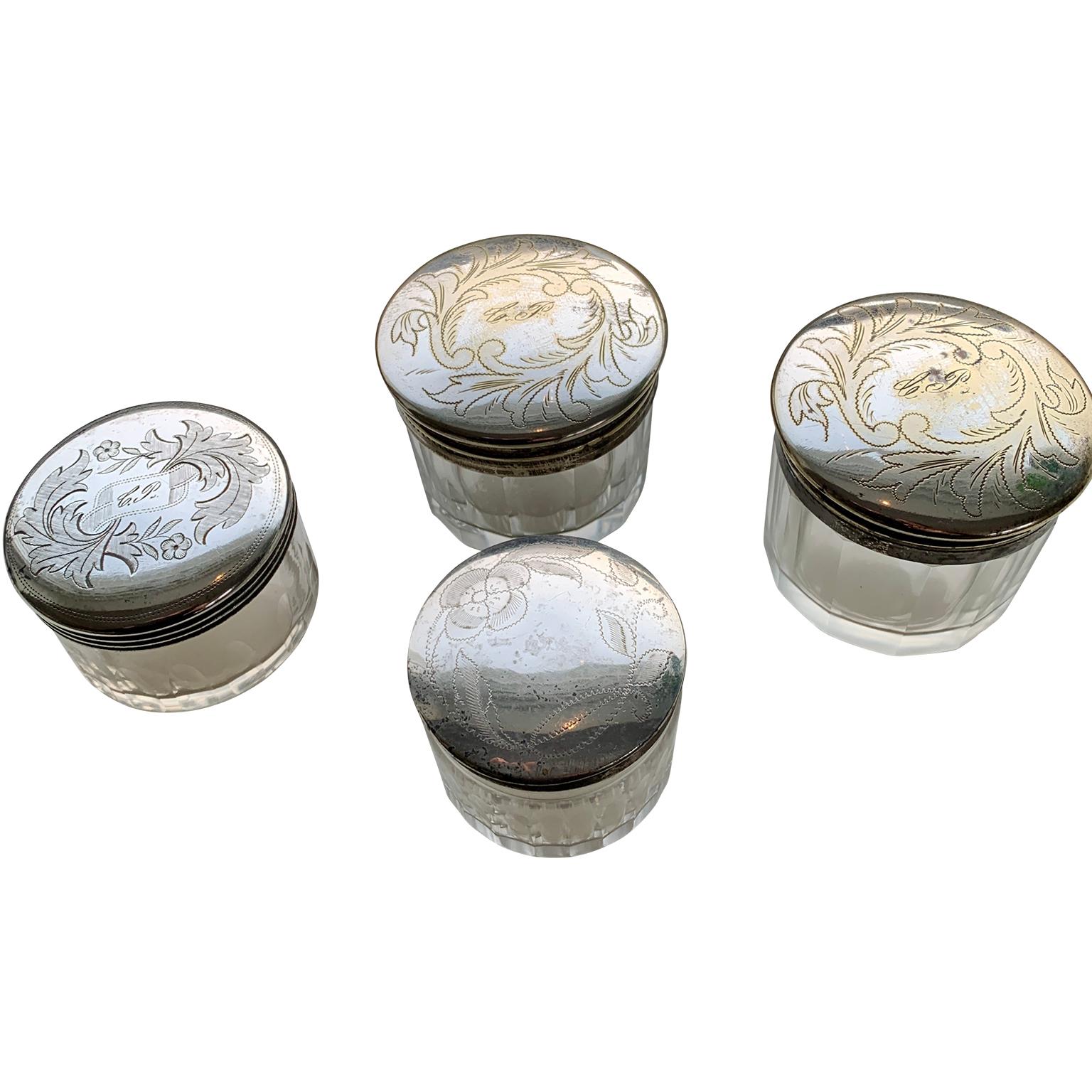 A set of four small round 19th Century trinket, candy or jewelry boxes in glass and silver plated brass from Sweden. The locks are engraved with a floral pattern and three of them have initials engraved as well. On the bottom they are also marked
