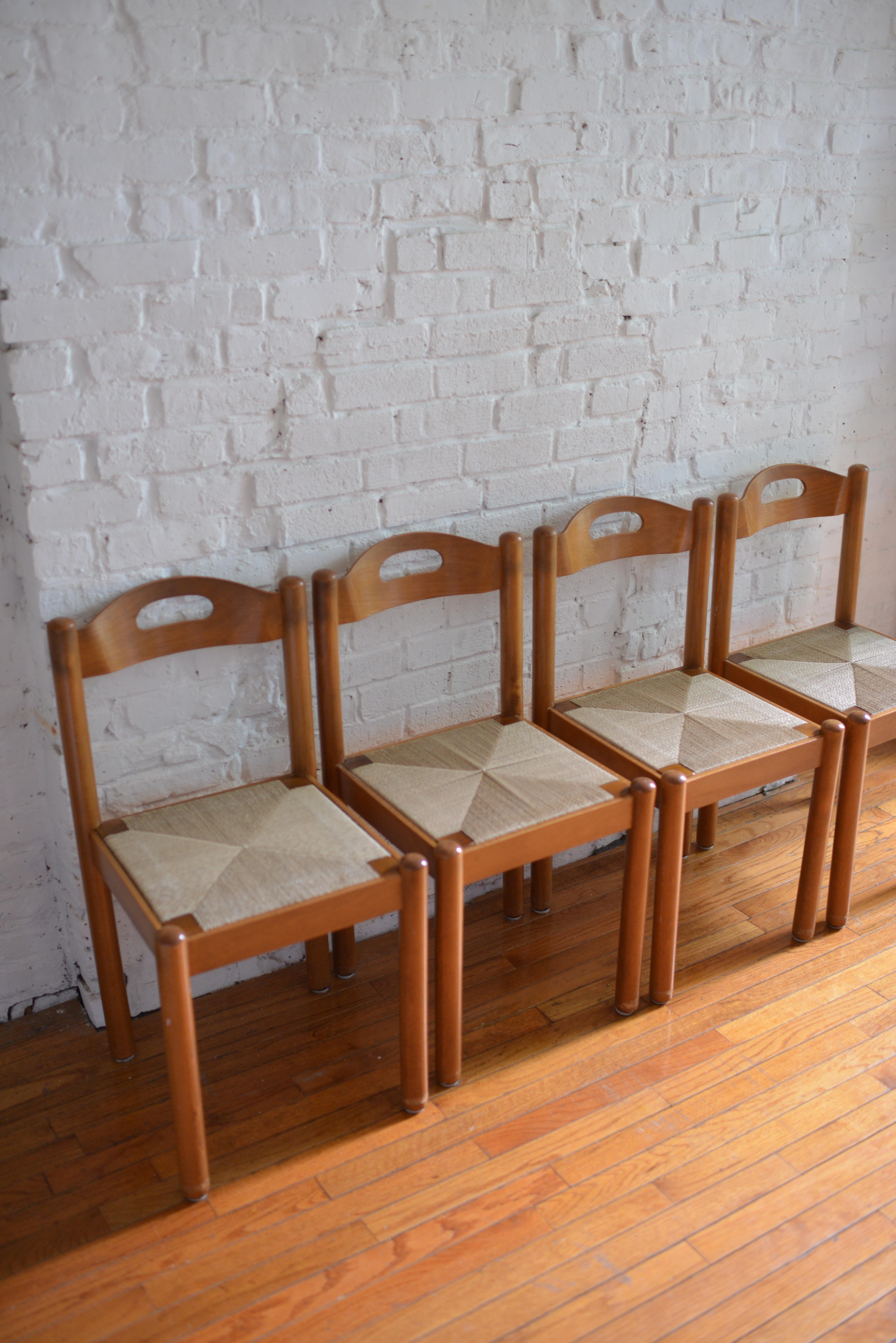 Set of 4 Mid-Century Modern dining chairs in the style of Vico Magistretti. Circular Maple framed and papercord rush woven seats with bent plywood back rests. Solid and sturdy chairs in great vintage condition. Marked 