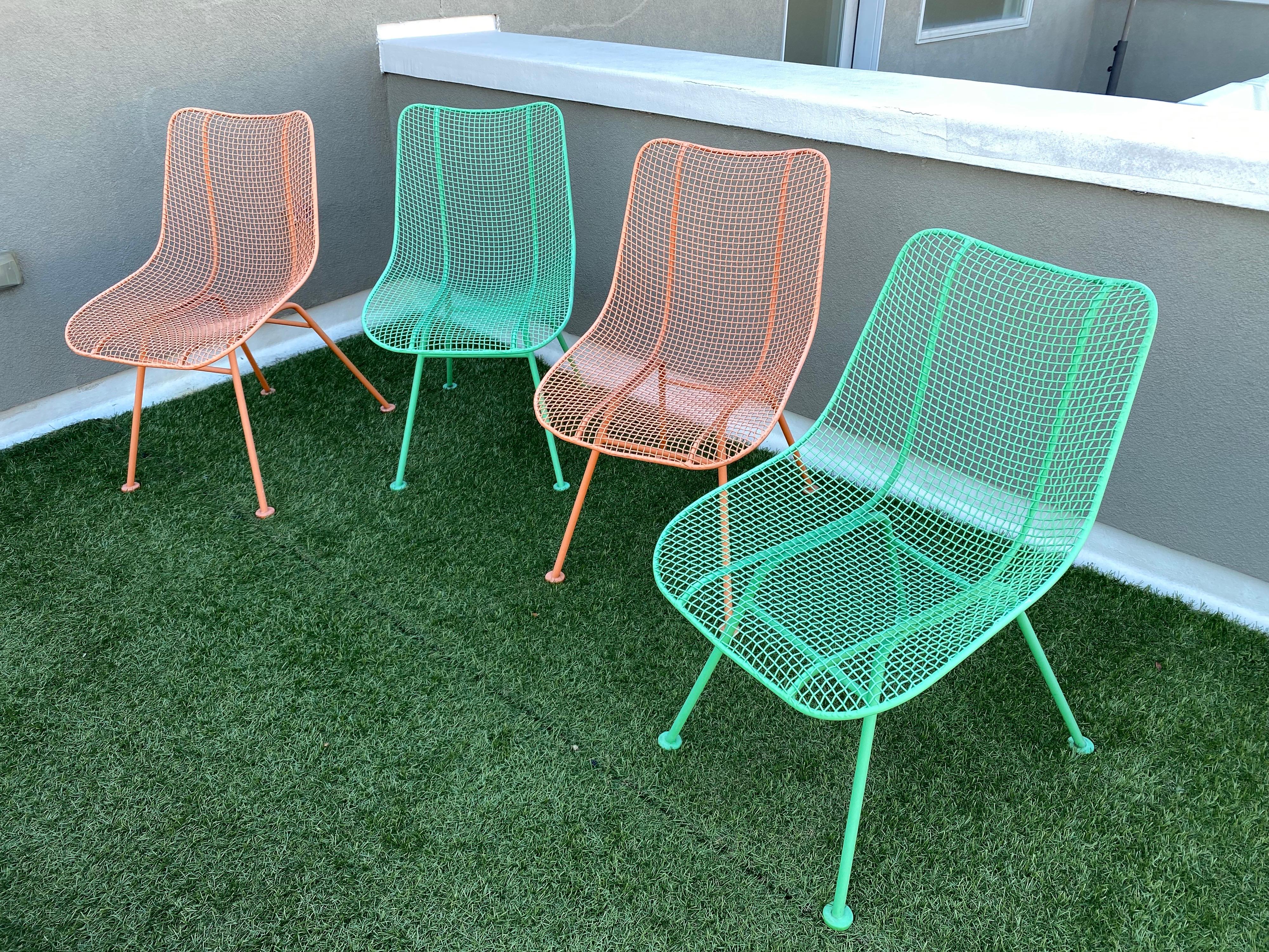 Set of 4 Russell Woodard slipper dining chairs. 2 orange and 2 green. Powder Coated about 15 years ago. Overall in good shape, but does show fading to paint. Entire set available.