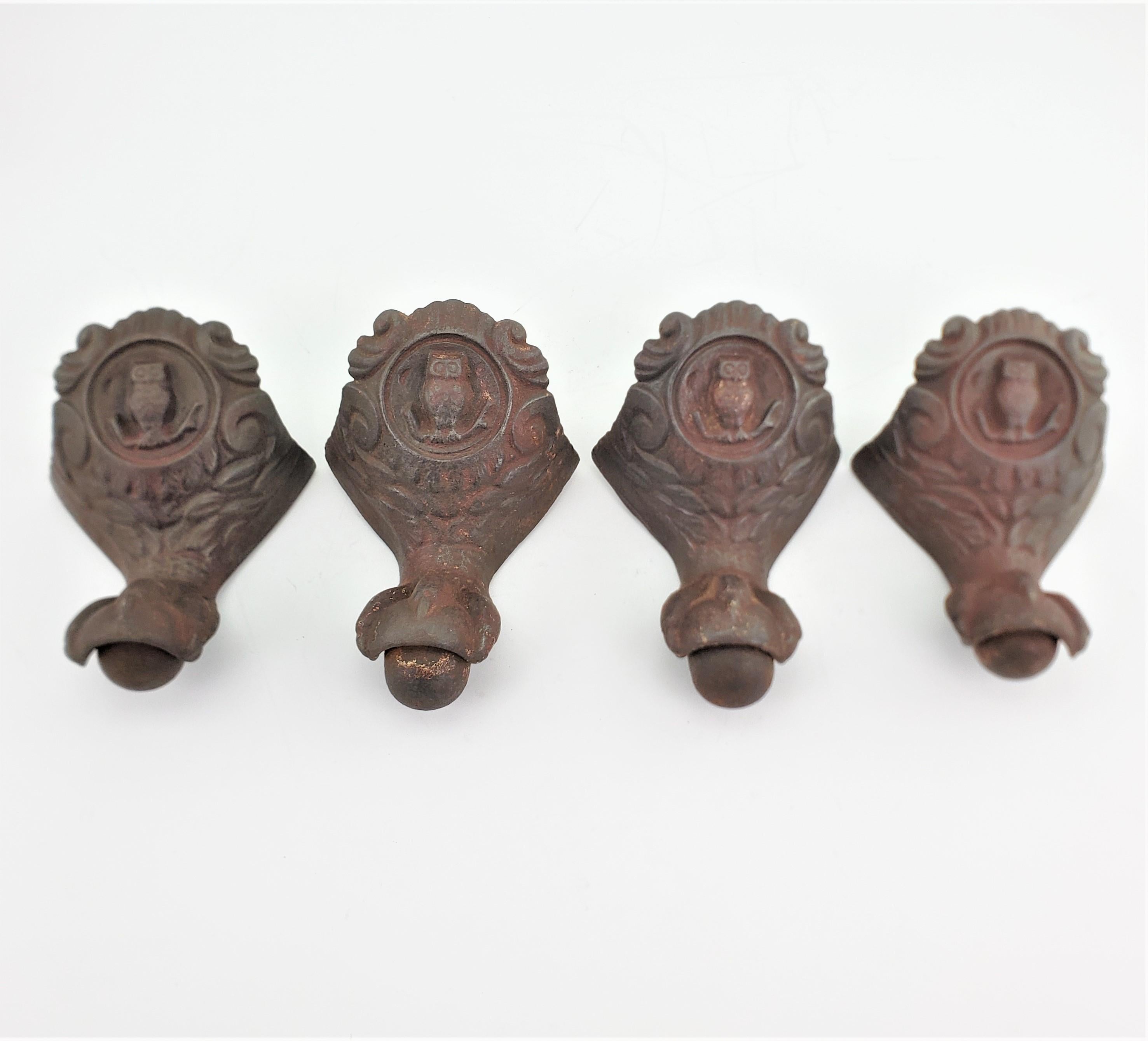 This set of four antique cast iron claw tub feet are unsigned, but presumed to have been made in the United States in approximately 1880 in the period Victorian style. The legs are ornately cast in iron with remnants of a brass toned patina, and are