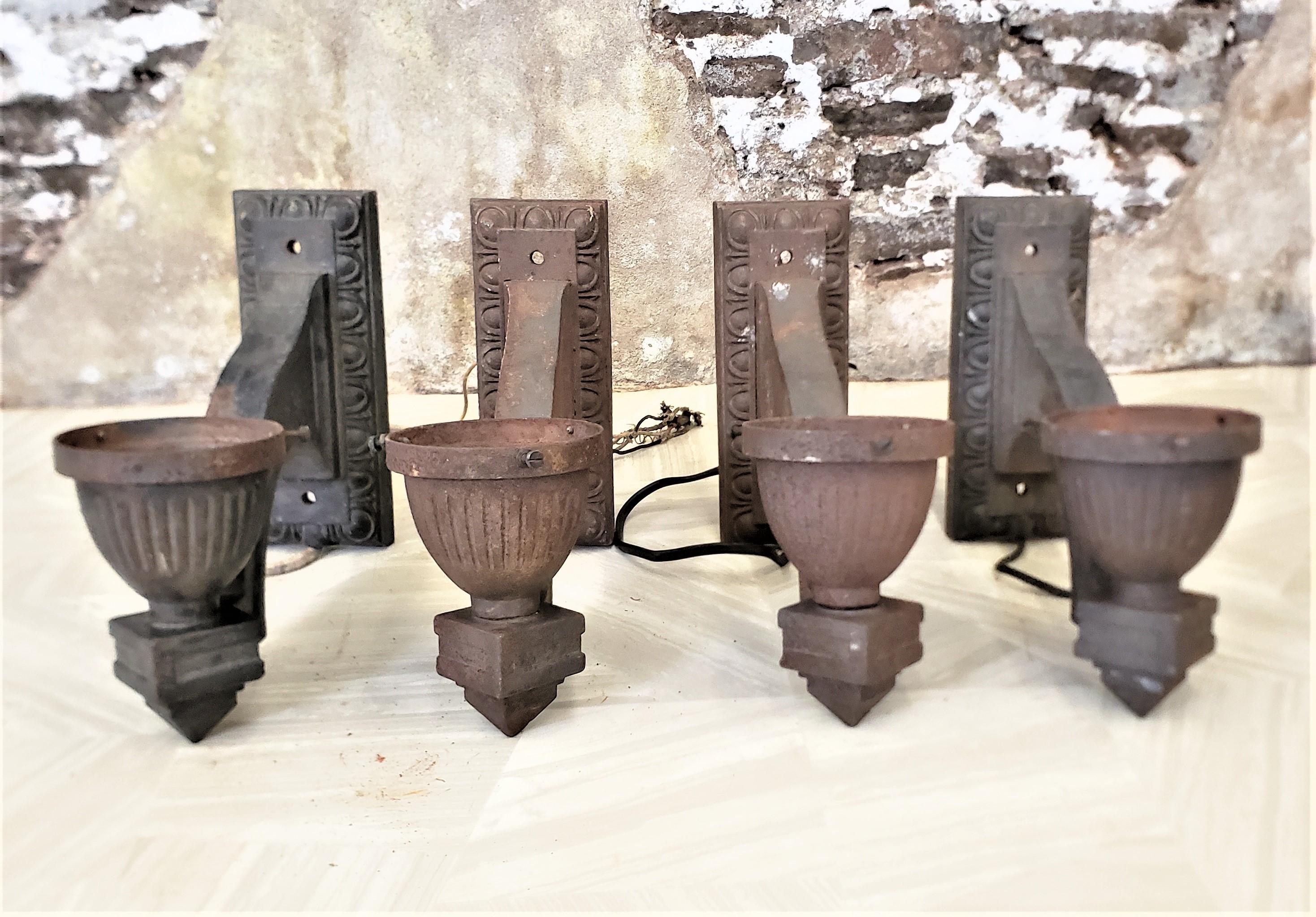 This set of four salvaged Art Deco cast iron architectural wall sconces have no maker's or foundry marks, but are presumed to have been made in the United States in approximately 1920 in a period style. These sconces are solid and quite heavy and