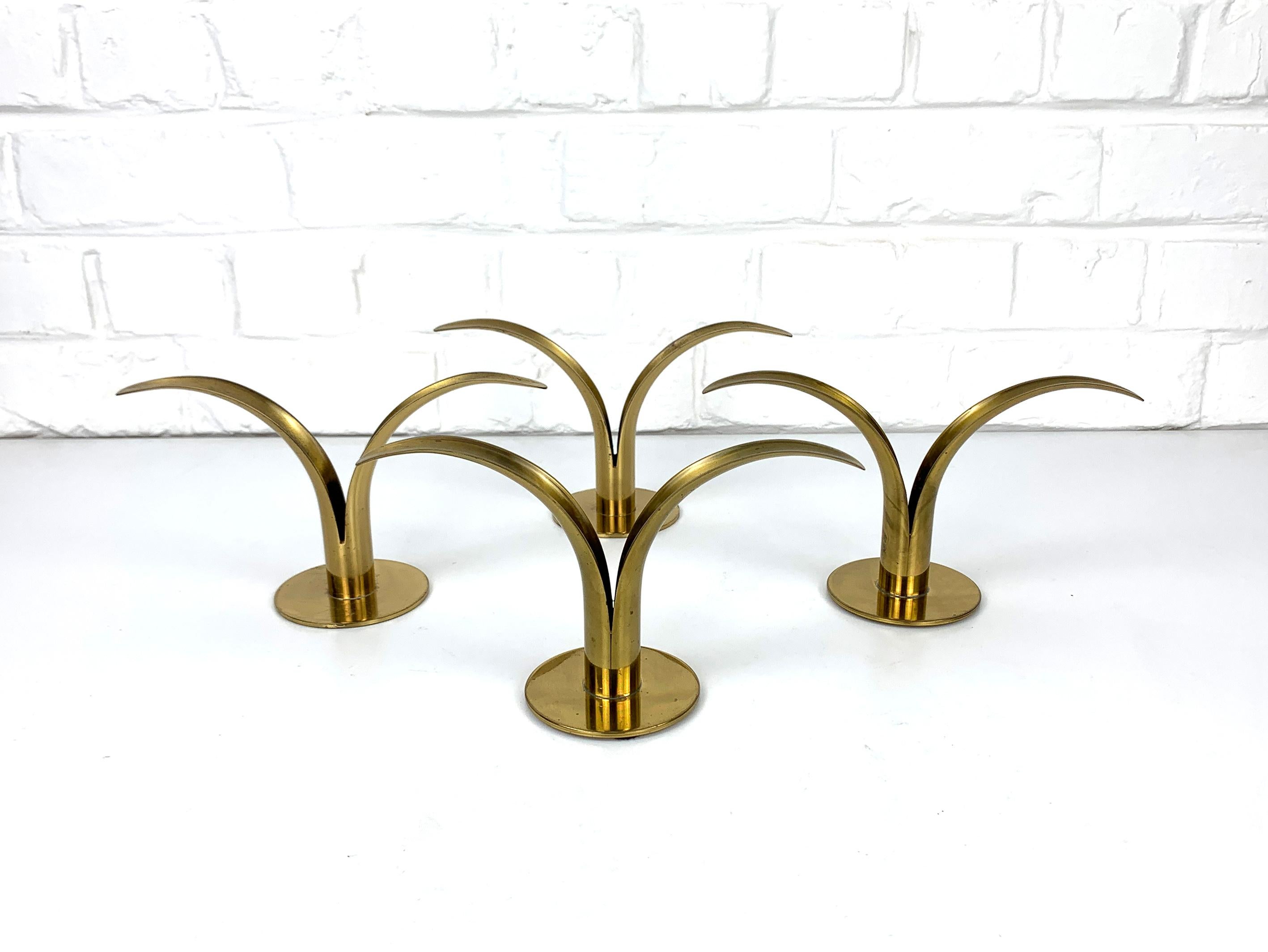 Set of 4 iconic mid-century brass candle holders “Lily”. 
Created by Ivar Ålenius-Björk in 1939. Made in Sweden by Ystad Metall.

Many copies on the market, but this is the real deal. 
Each of them is signed beneath. 
Made of massive brass with