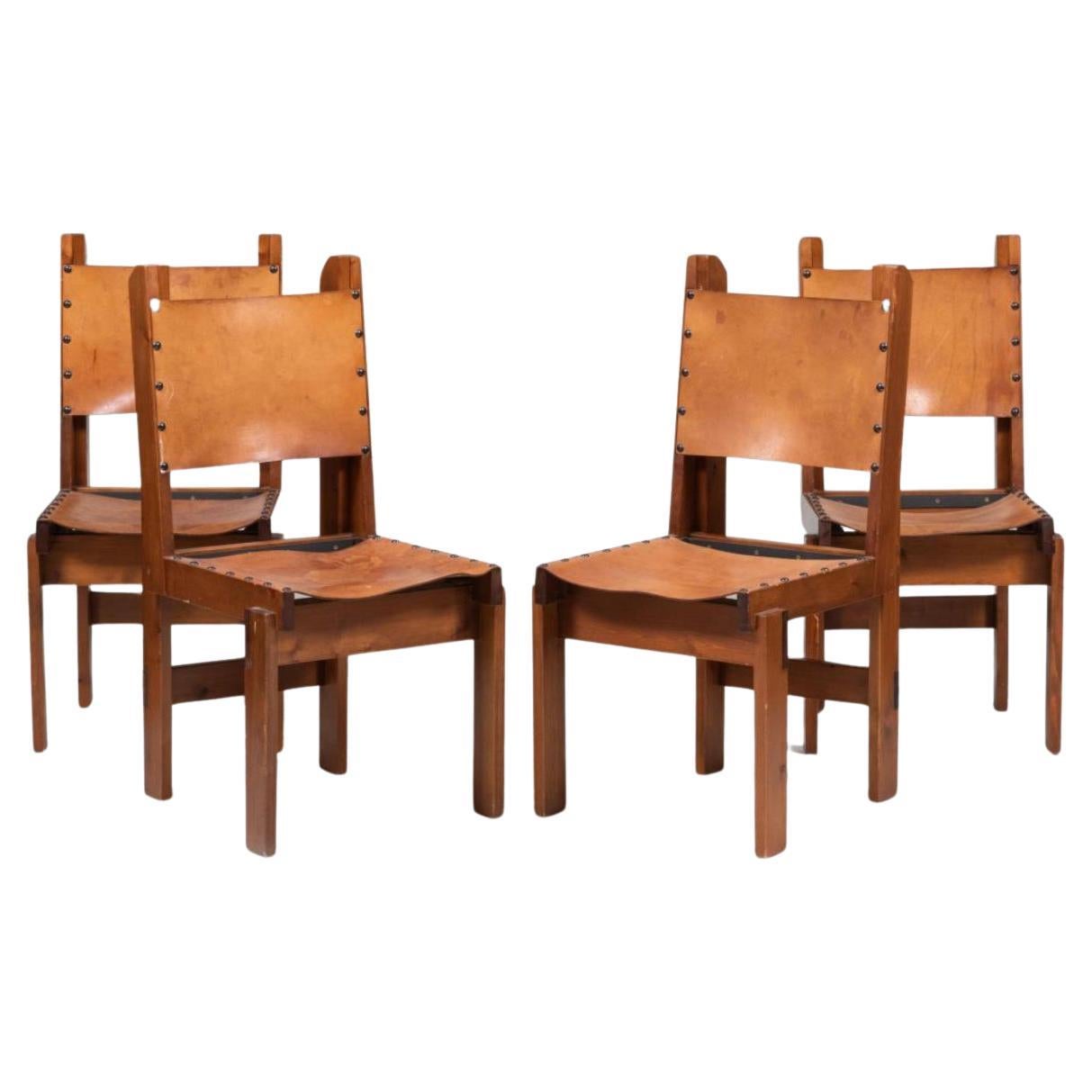 Set of (4) Scandinavian Modern Brutalist Pine and Leather Sling armless Dining Chairs. Solid Pine wood stained with Tan thick leather sling seat and backrest. Leather seats do show Patina. Chairs seem to be Custom Made/Designed. Unmarked Located in