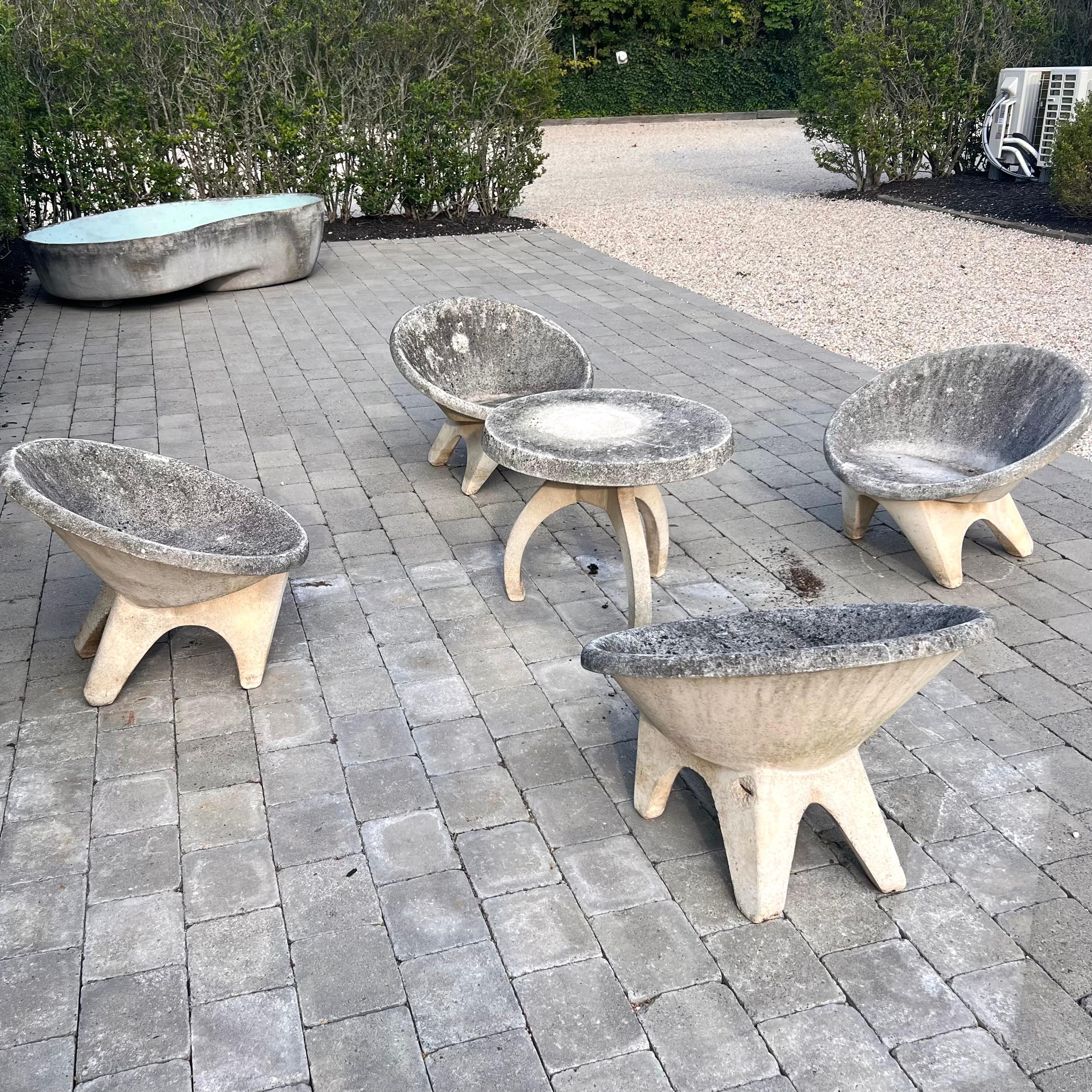 Stunning outdoor set consisting of four chairs with a matching table, all made of solid concrete. Round saucer seat with angular legs. Incredible modern design with very fantastic patina. Factory drilled hole in each chair for water to drain. Great