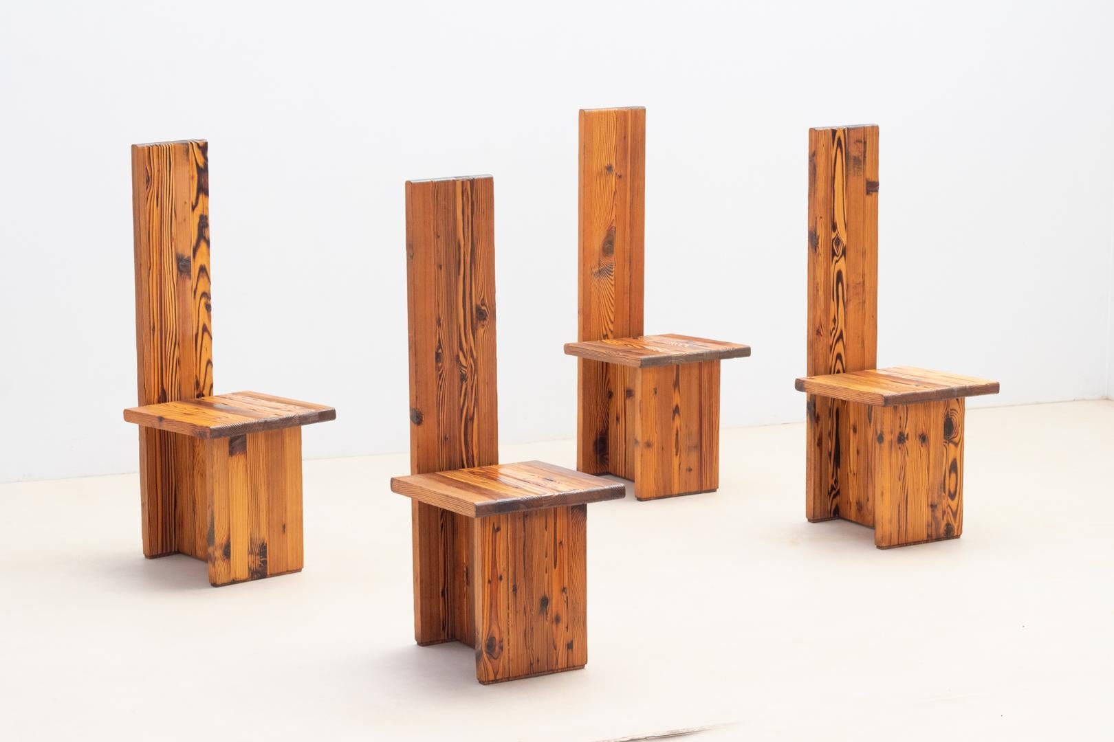 Set of four minimalist chairs with architectural lines and burnt pine finish in the spirit of Japanese Shou Sugi Ban technique.
The set with clean lines, a kind of regressive lines, features a high backrest that recalls the regal height of thrones.