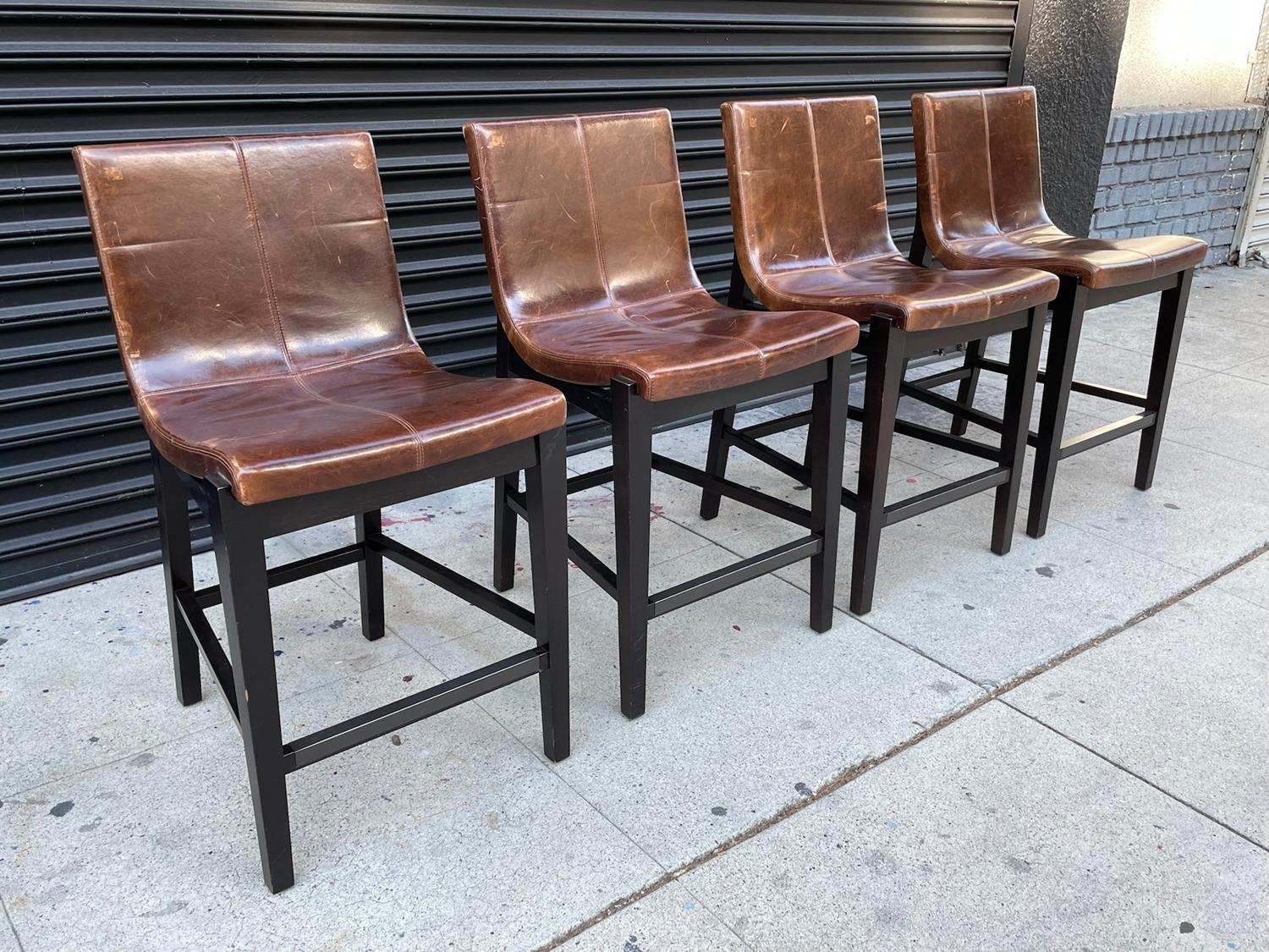 Beautiful set of 4 counter stools designed and manufactured in the US by Holly Hunt and part of the Sirene collection.

The stools have beatiful lines, the dark woden frames have great architectural lines and the brown leather is warm and